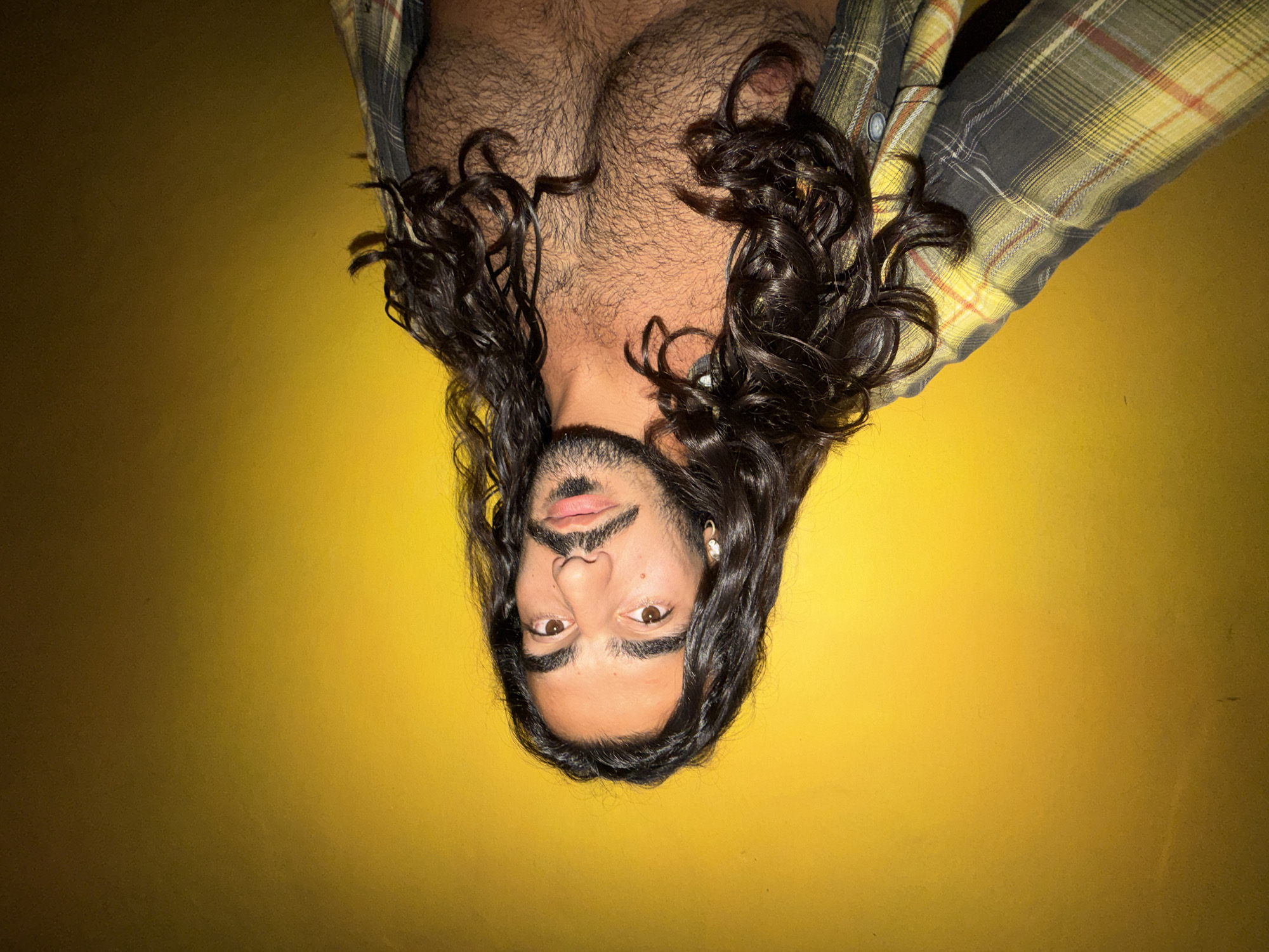 Man takes selfie series against yellow wall in Bali