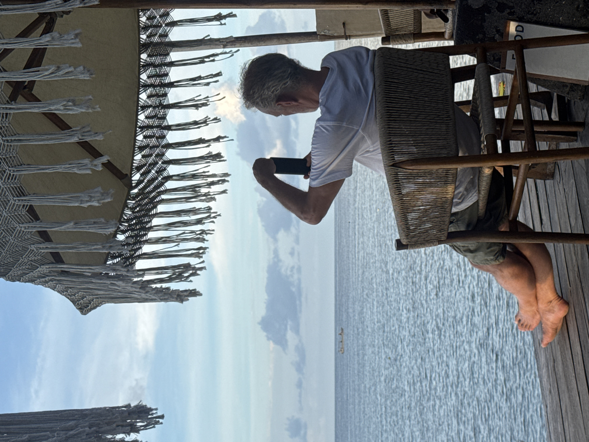 Tourist photographs ocean view at Nusa Penida beach bar