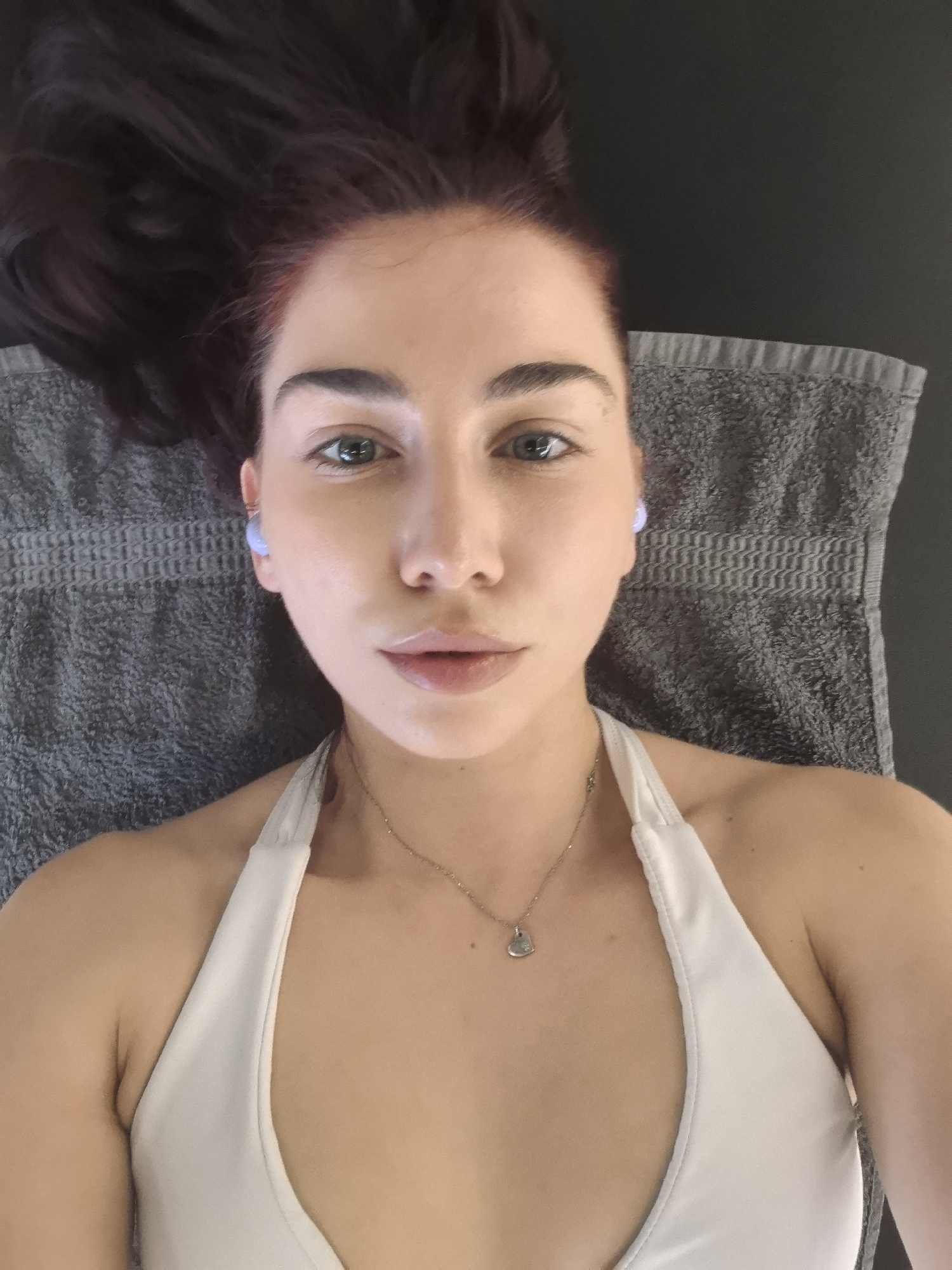 Woman rests during workout session wearing white athletic wear