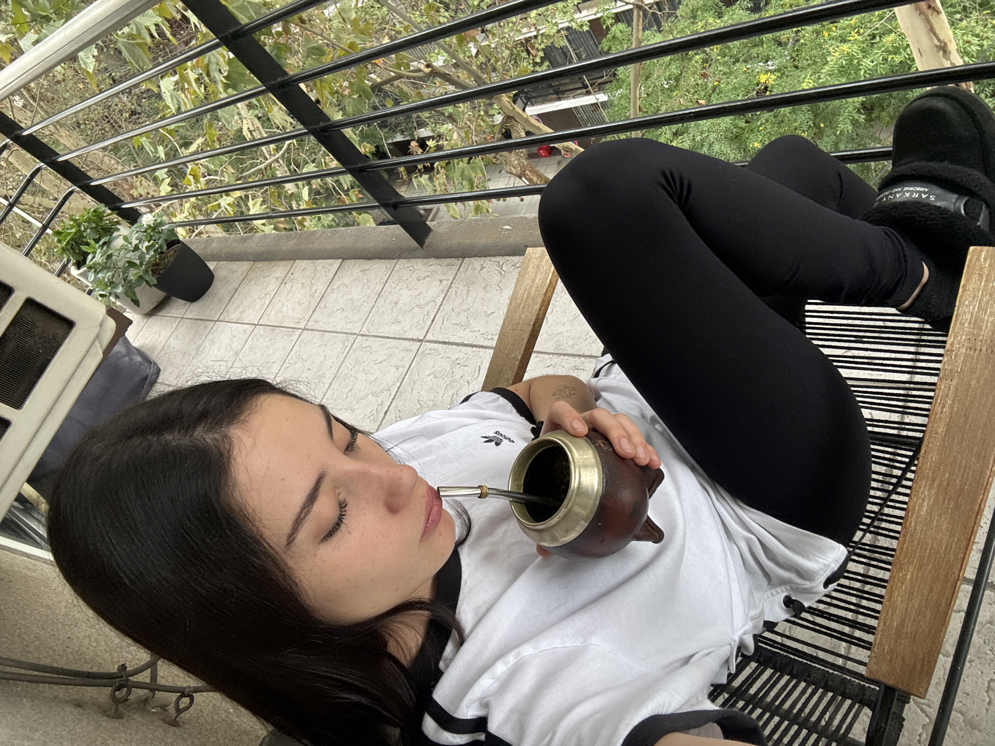 Woman enjoys mate tea, healthy snacks on Buenos Aires balcony