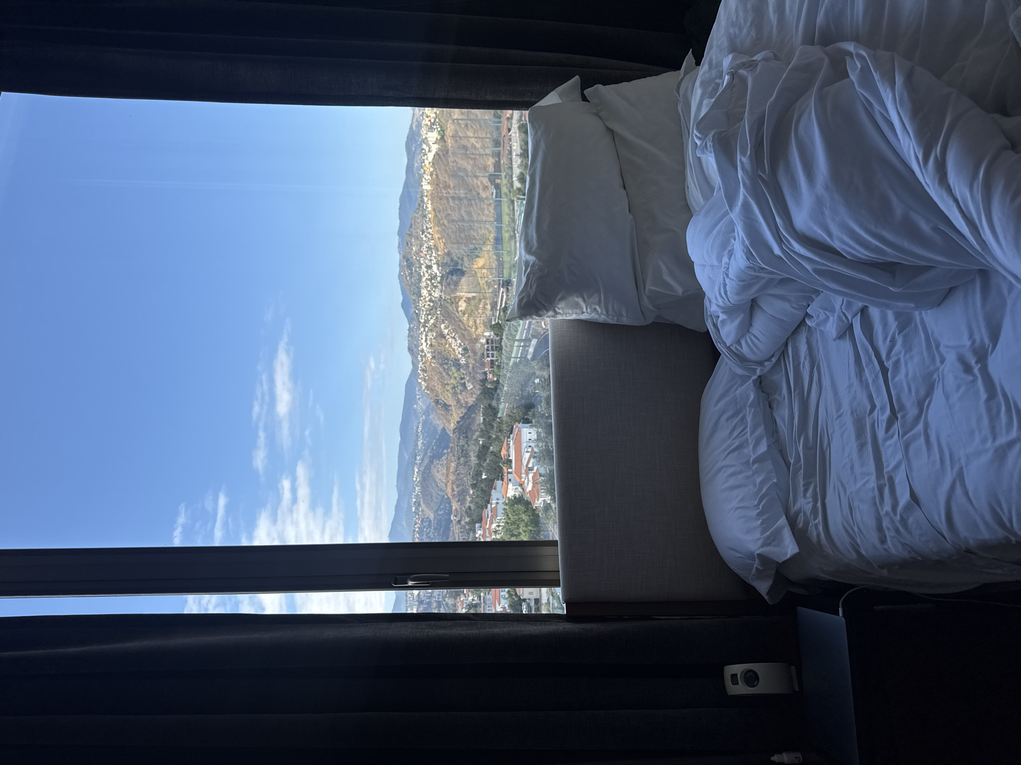 Hotel room view captures mountains and residential area