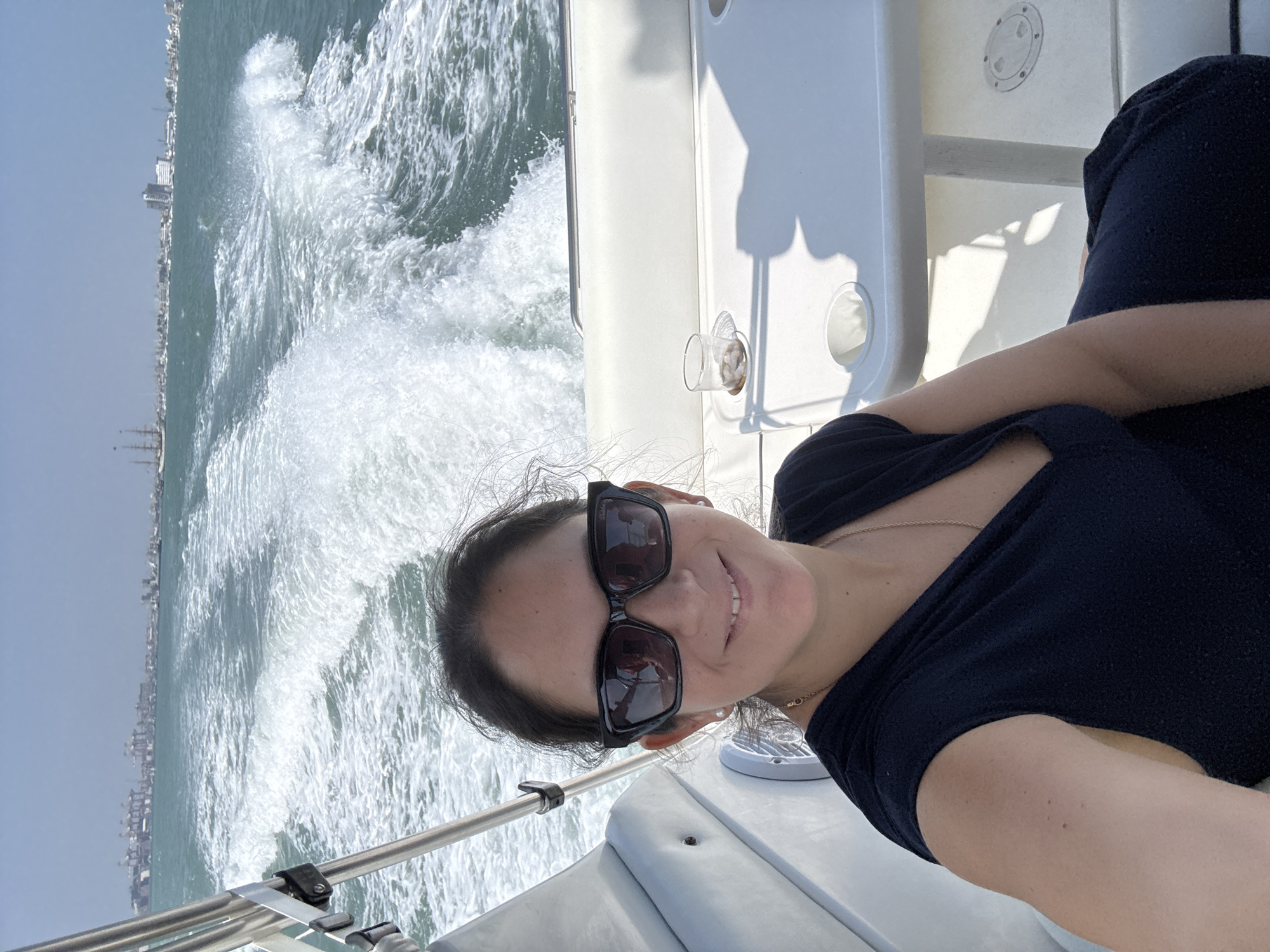 Woman takes boat selfie near anchored sailboats in Peru