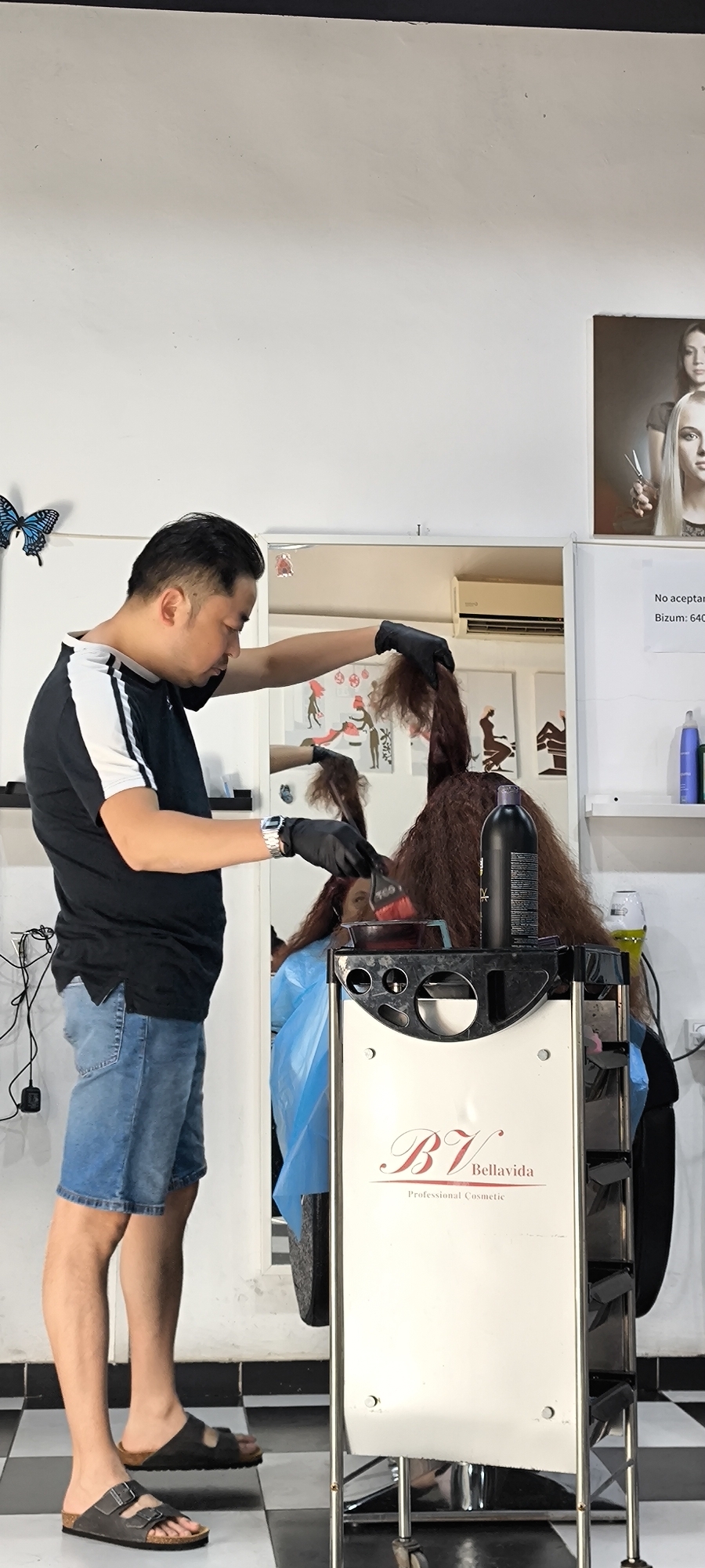 Hair stylist applies dye to client in Ripollet