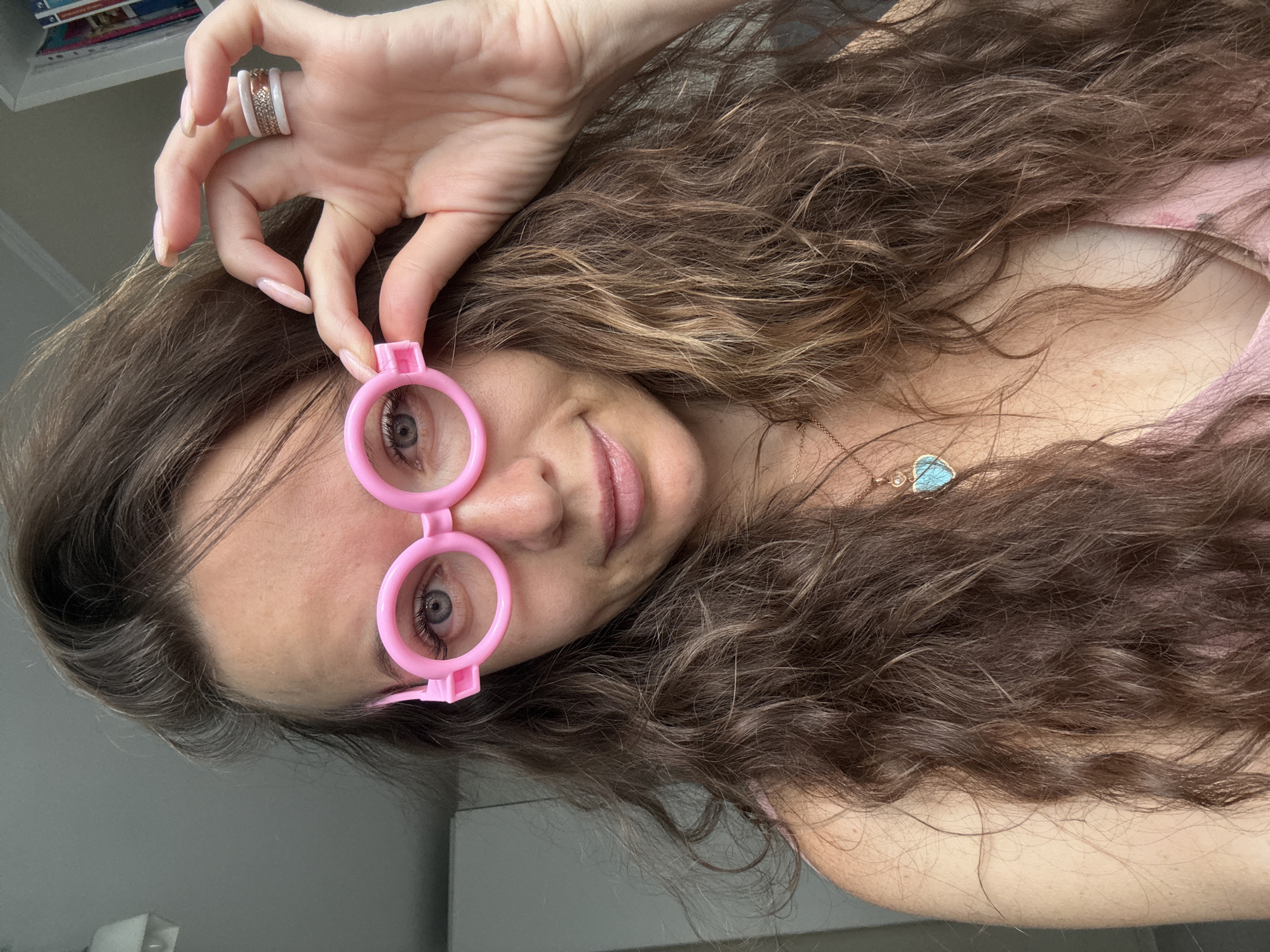 Trying on pink novelty glasses at home in Moscow