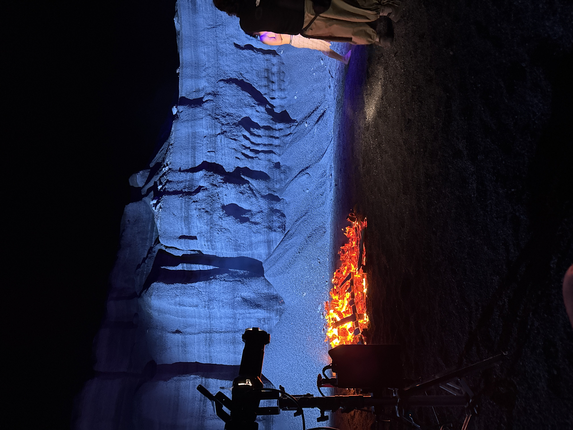 Two people rest near illuminated rock formation in Teguise