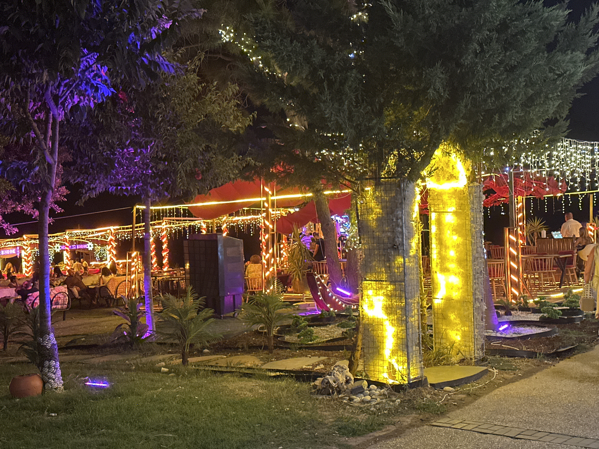 Festive outdoor dining scene lit up in Konyaaltı at night