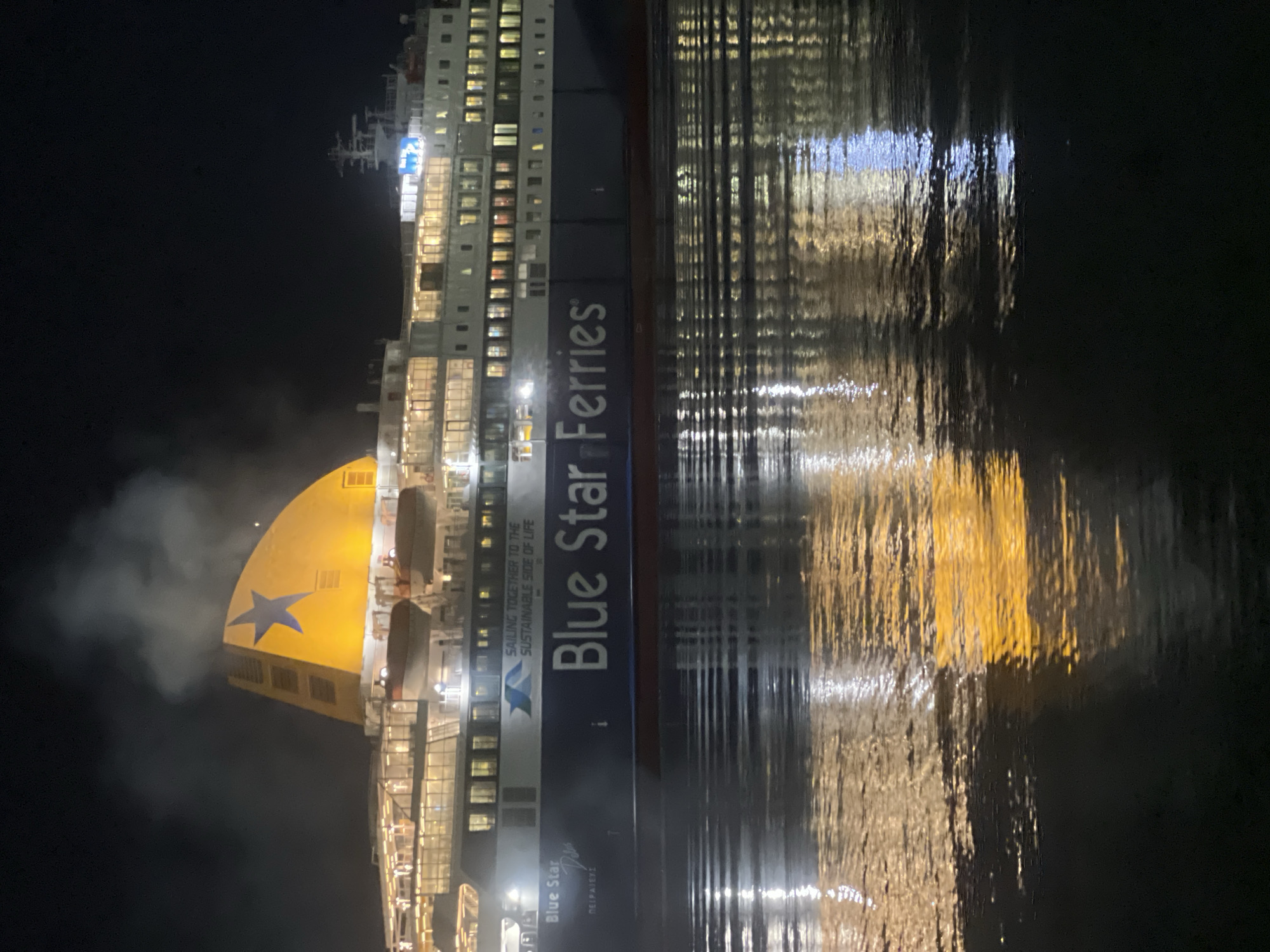 Blue Star Ferry emits steam in Piraeus harbor at night