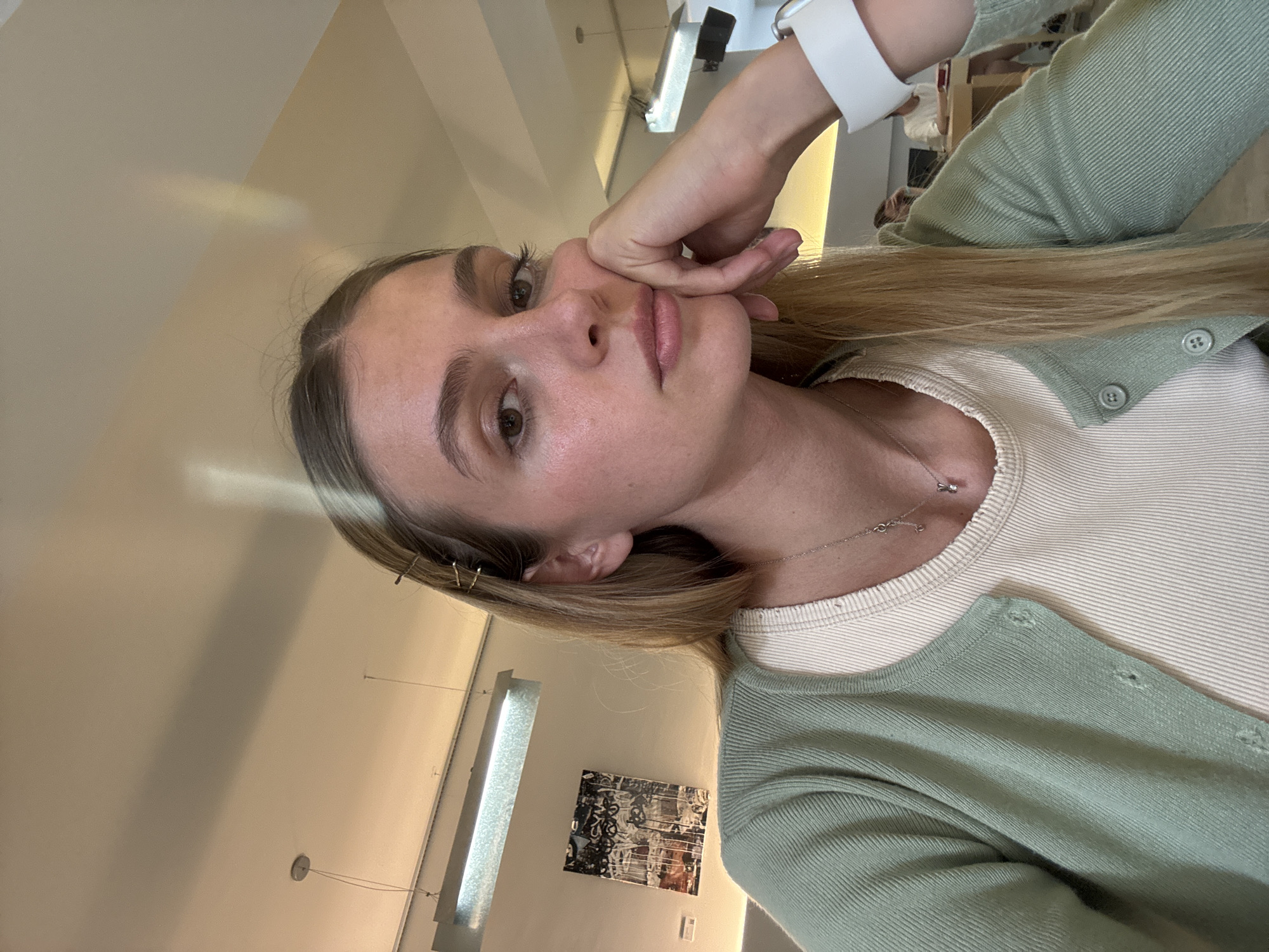 Woman takes selfie in green cardigan