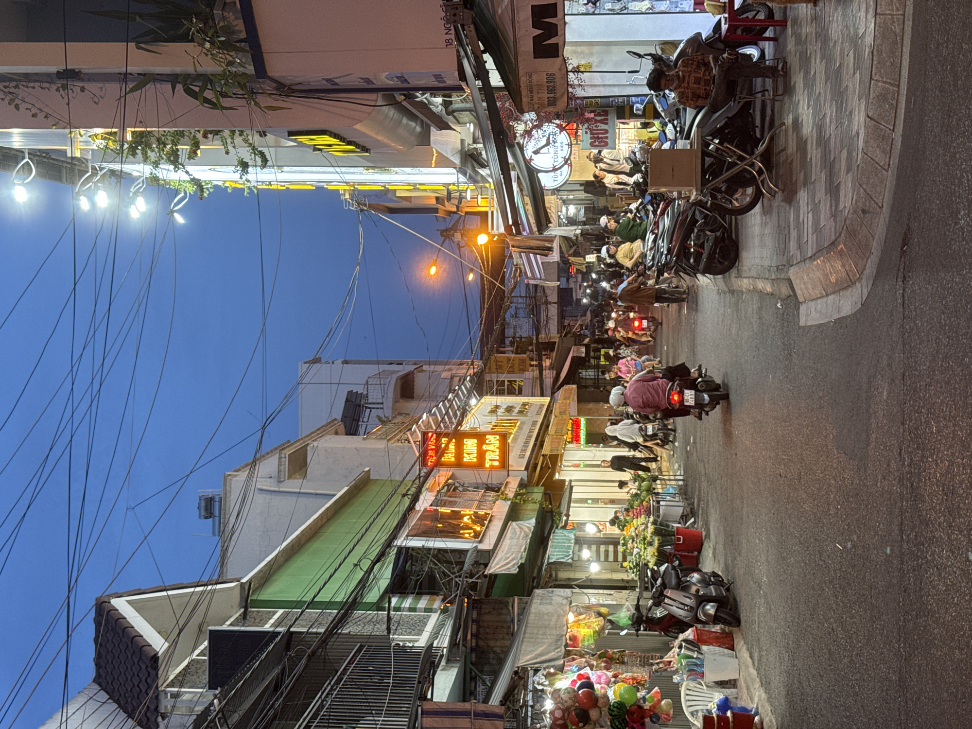 Phan Thiết street scene at dusk, shophouses lining the road