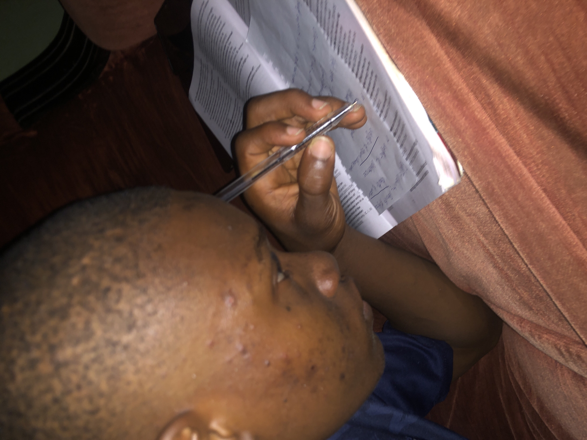 Student studies with textbook on couch in Atani home