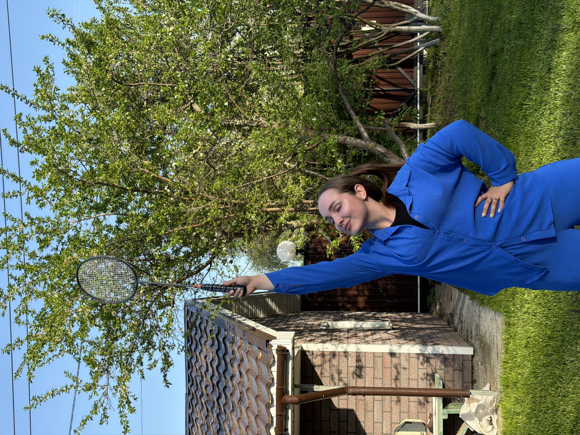 Family badminton gathering in Chaikovsky backyard during spring afternoon