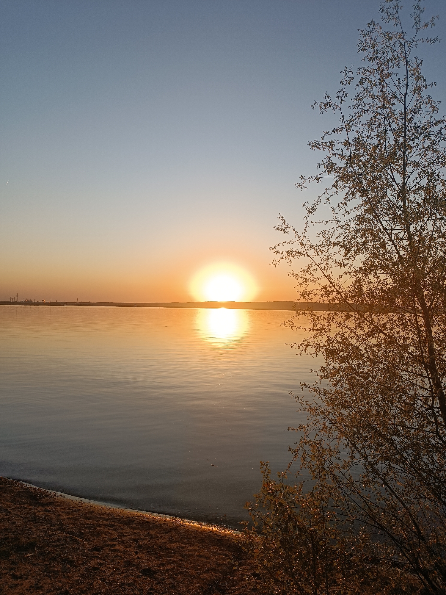 Woman captures sunset moments along Kama River in Chaikovsky