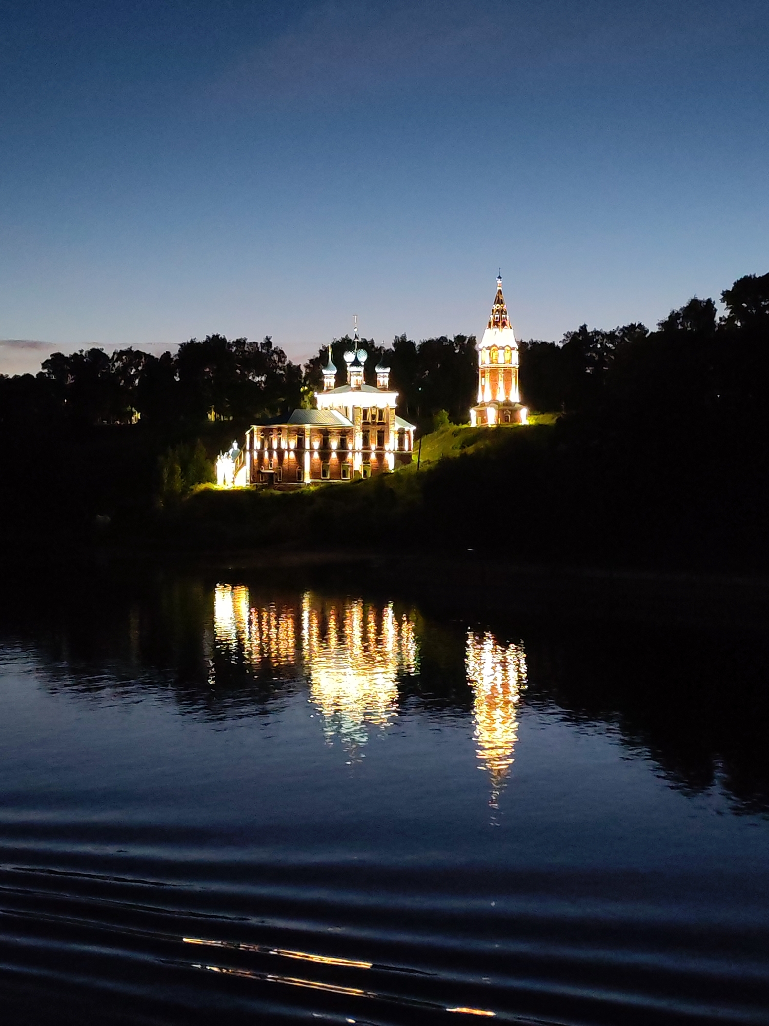 Tutaev's illuminated cathedral complex reflected on the Volga at night