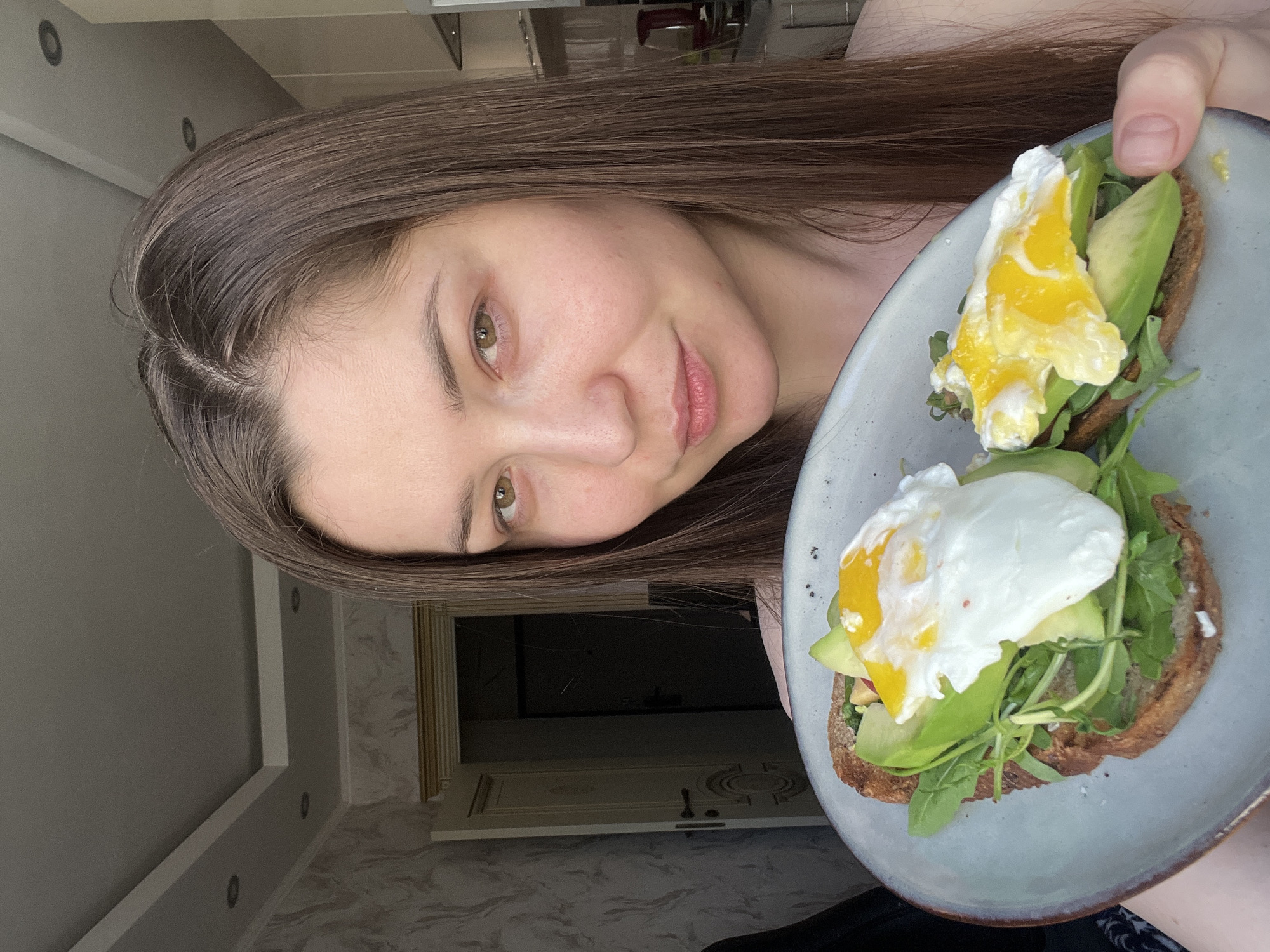 Woman enjoys homemade avocado toast breakfast in Khimki kitchen
