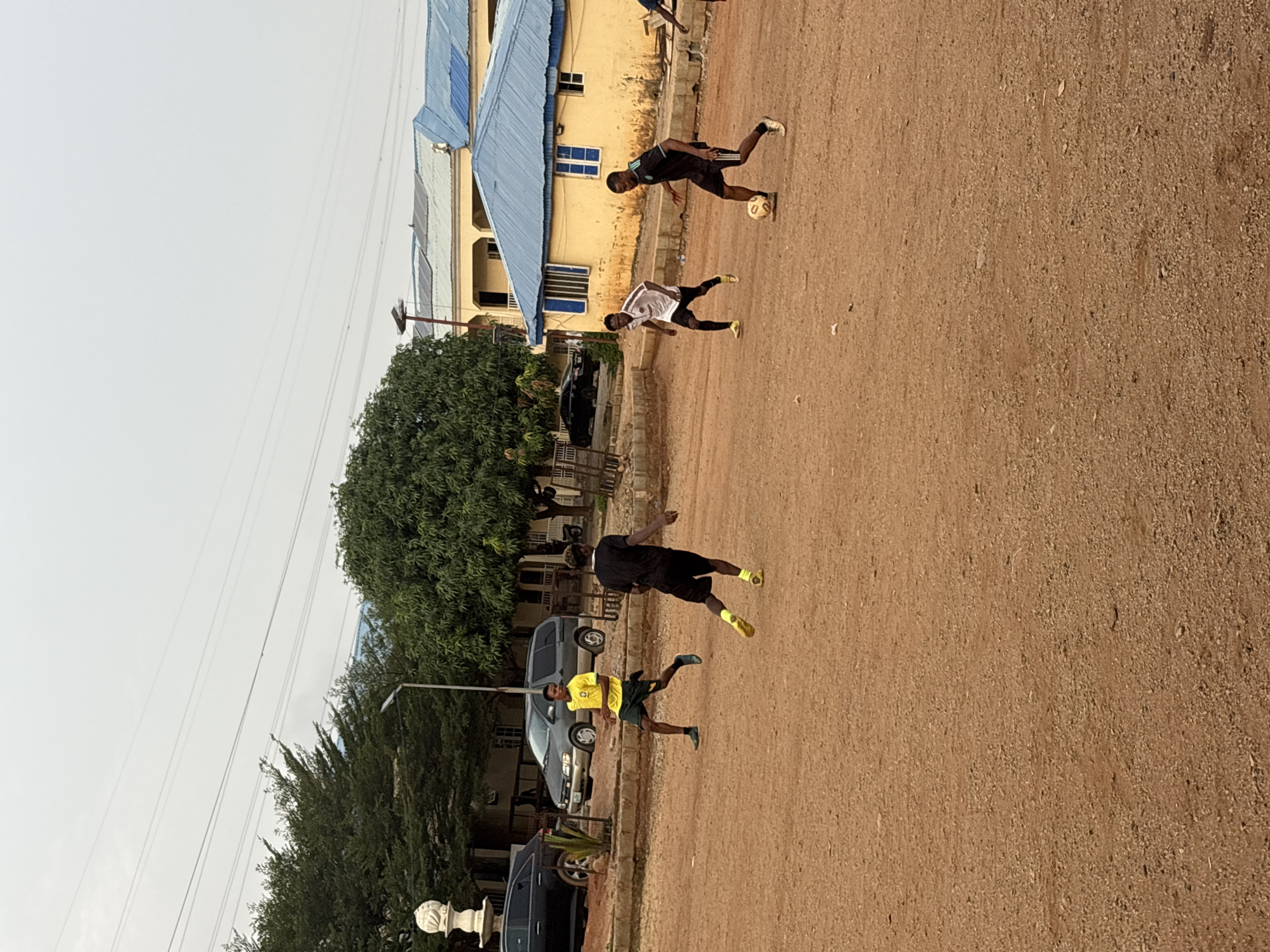 Young men play informal soccer match in Nigerian neighborhood