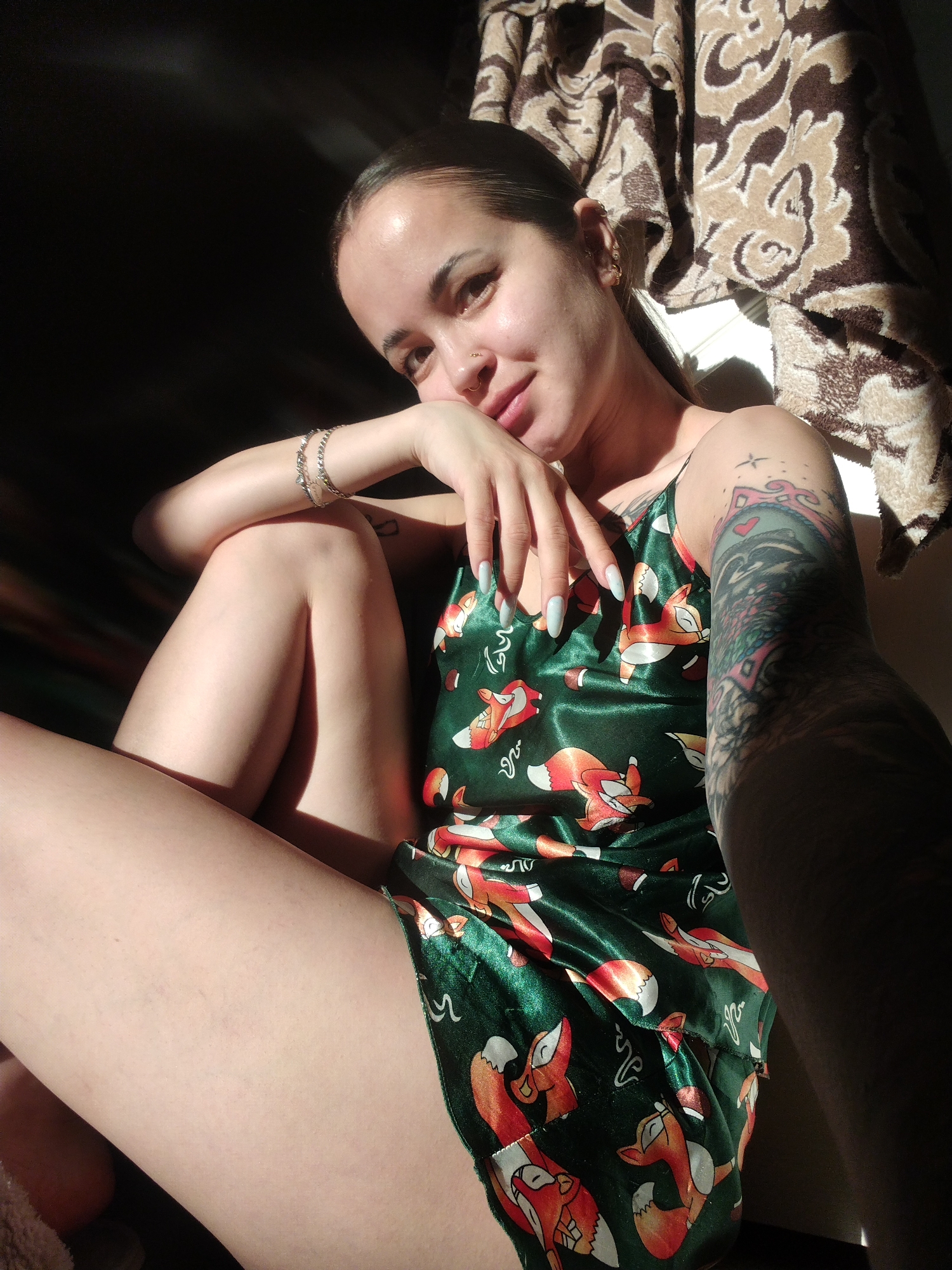 Person in fox-print pajamas photographed indoors with multiple piercings