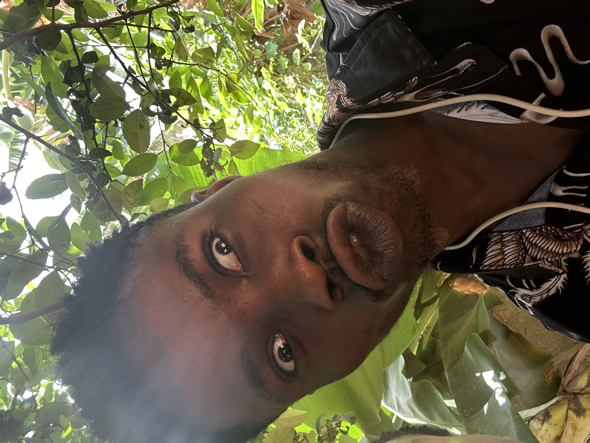 Man takes playful selfies among tropical plants during morning session