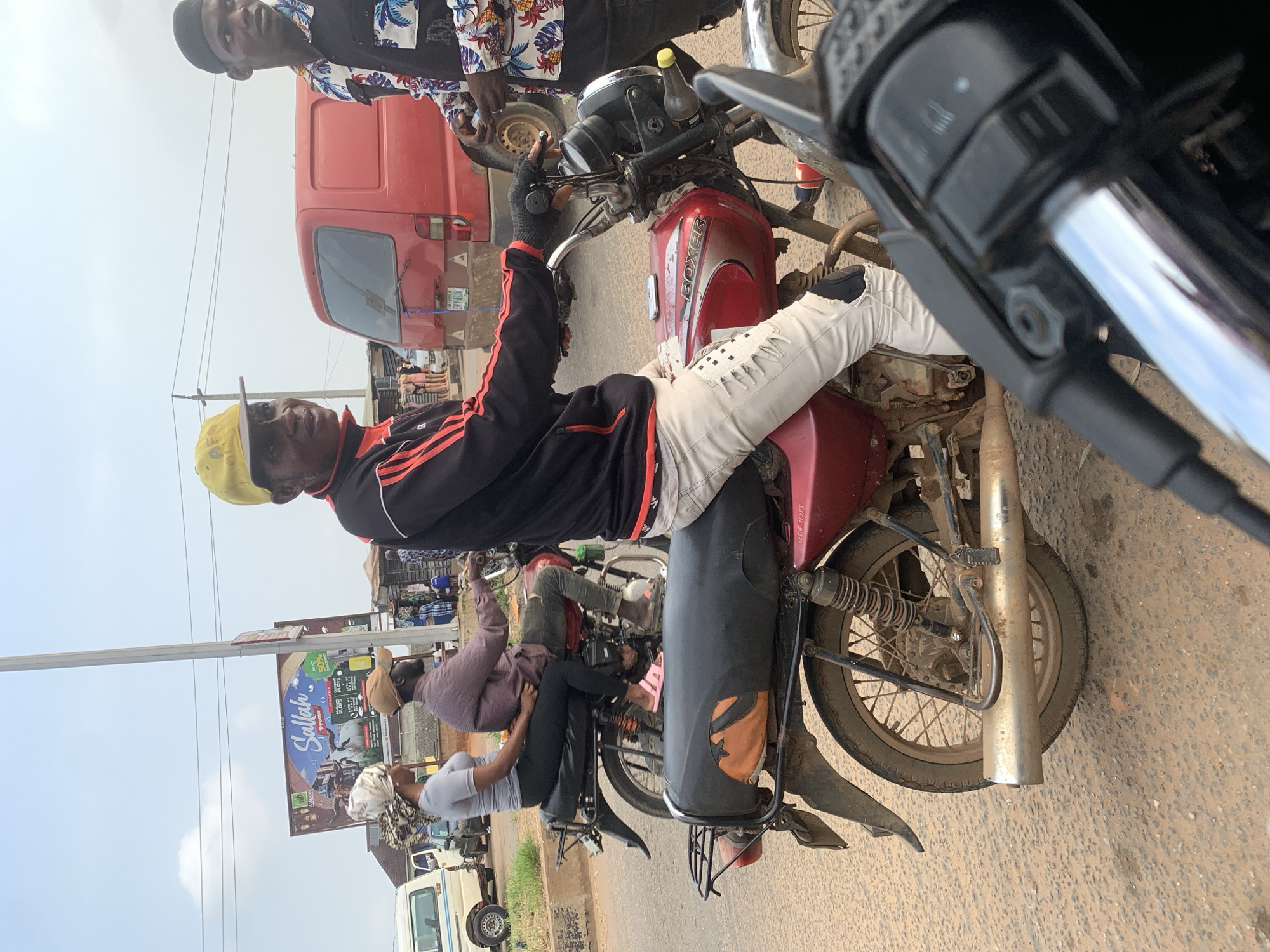 Motorcycle traffic and street life along a Shagamu road
