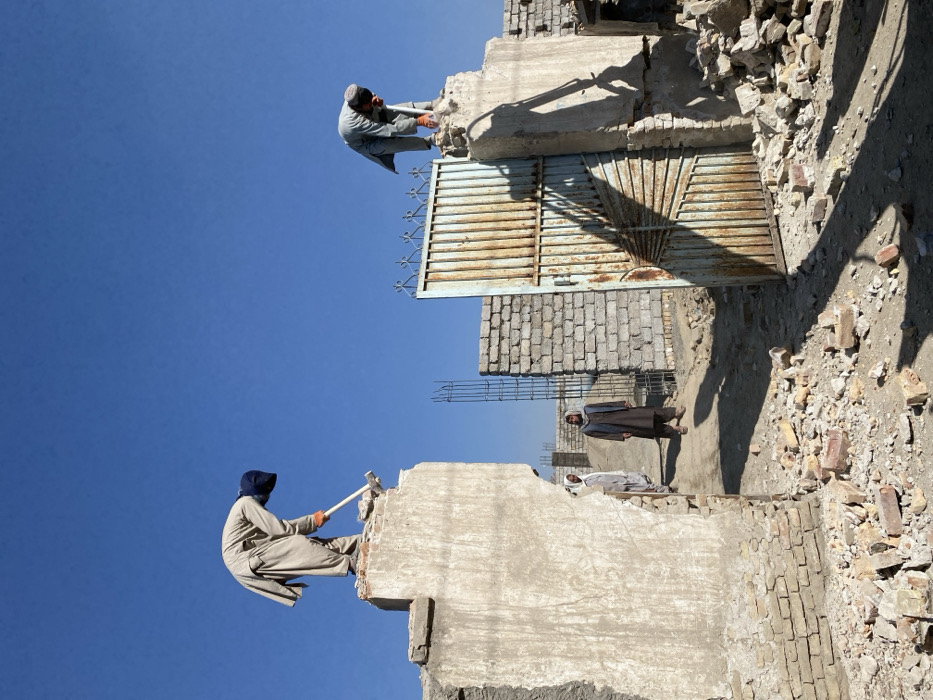 Workers demolish concrete gate structures in Kandahar