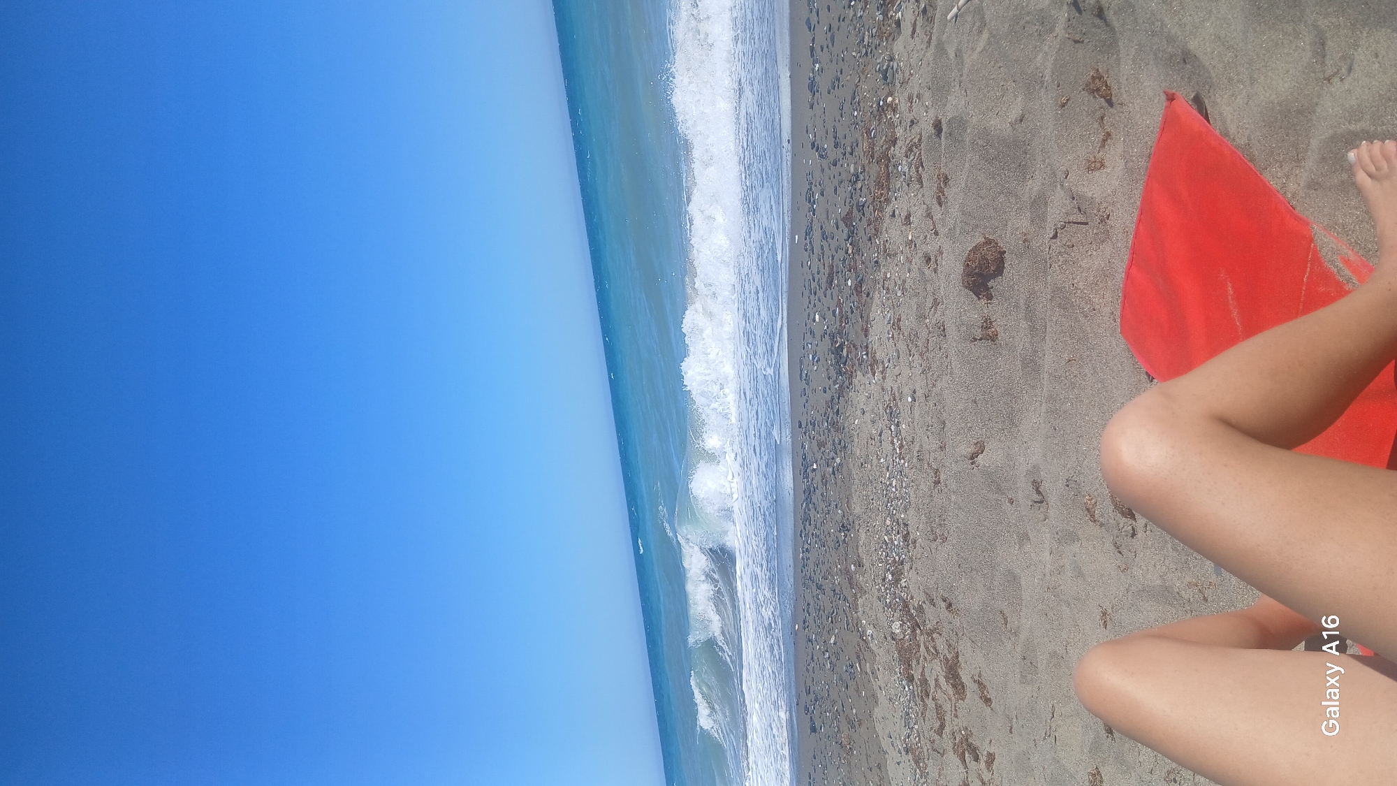 Sunny beach day with colorful umbrella and crashing waves