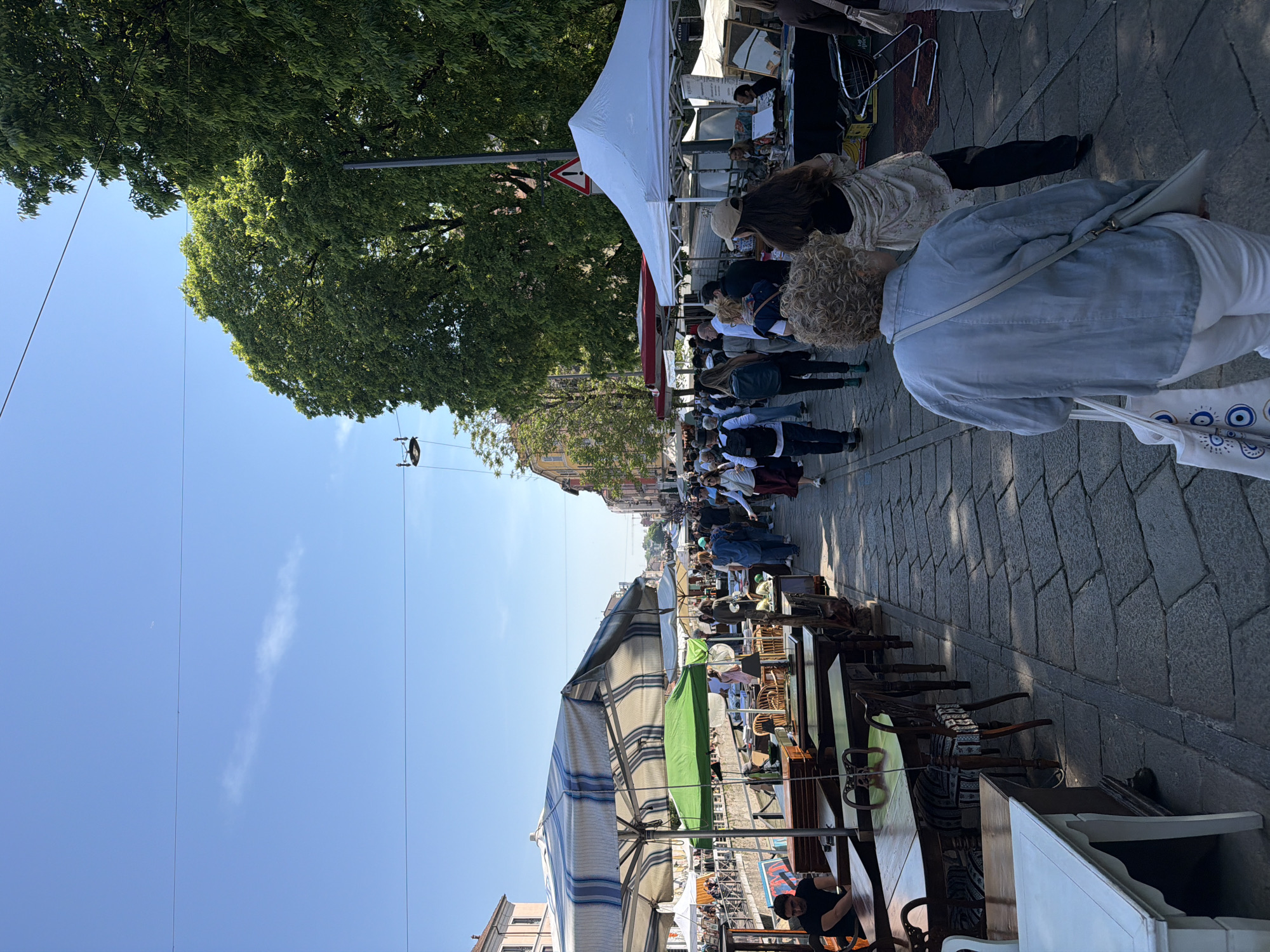 Market crowd walks between vendor stalls in Milan