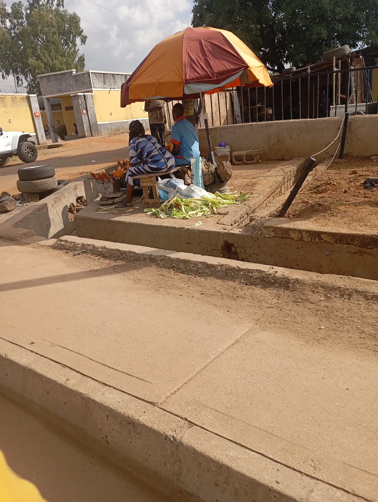 Afternoon street life and vendor activity near Jos's New Stadium
