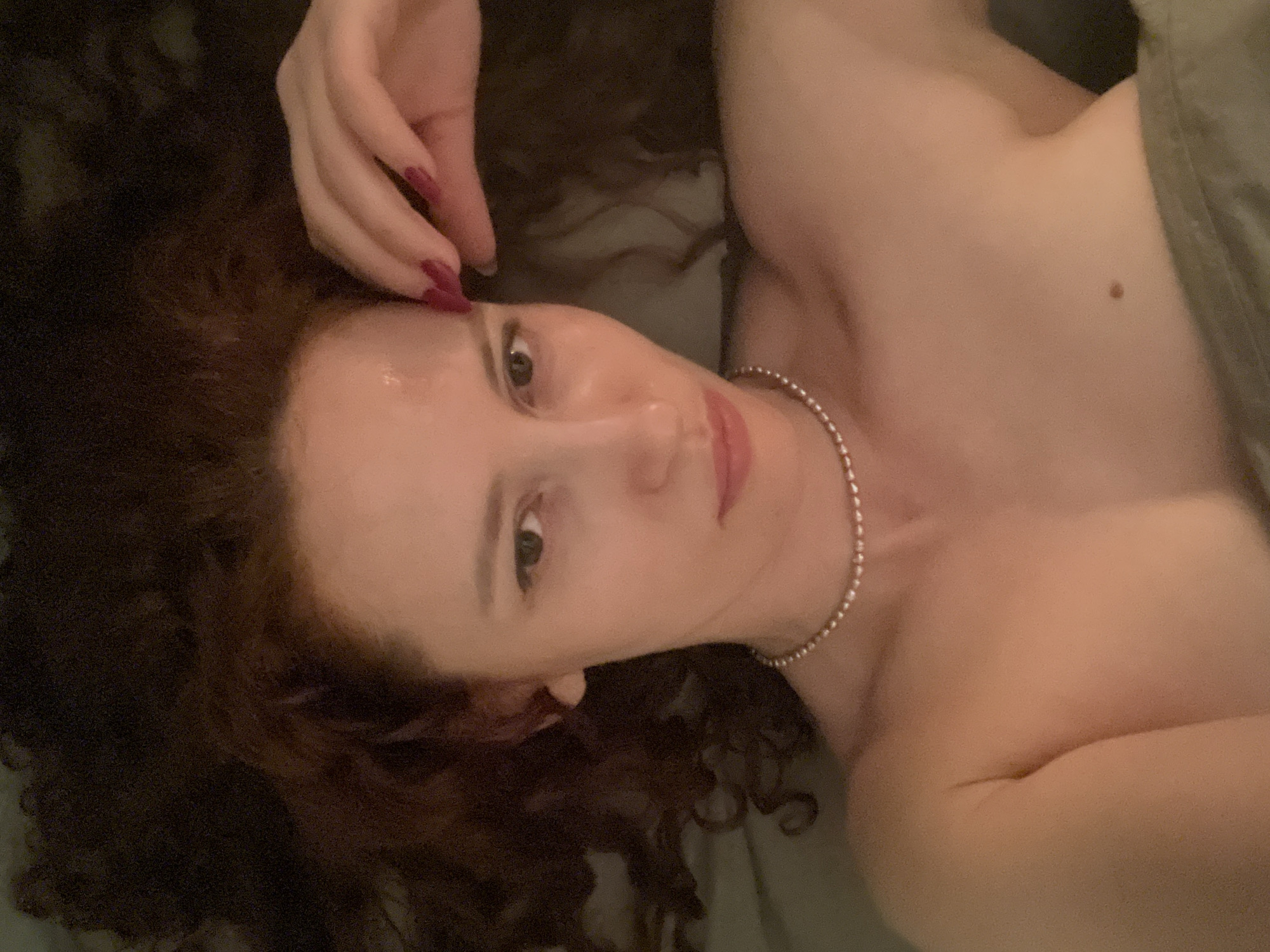 Red-haired woman resting with hand to forehead in Saint Petersburg