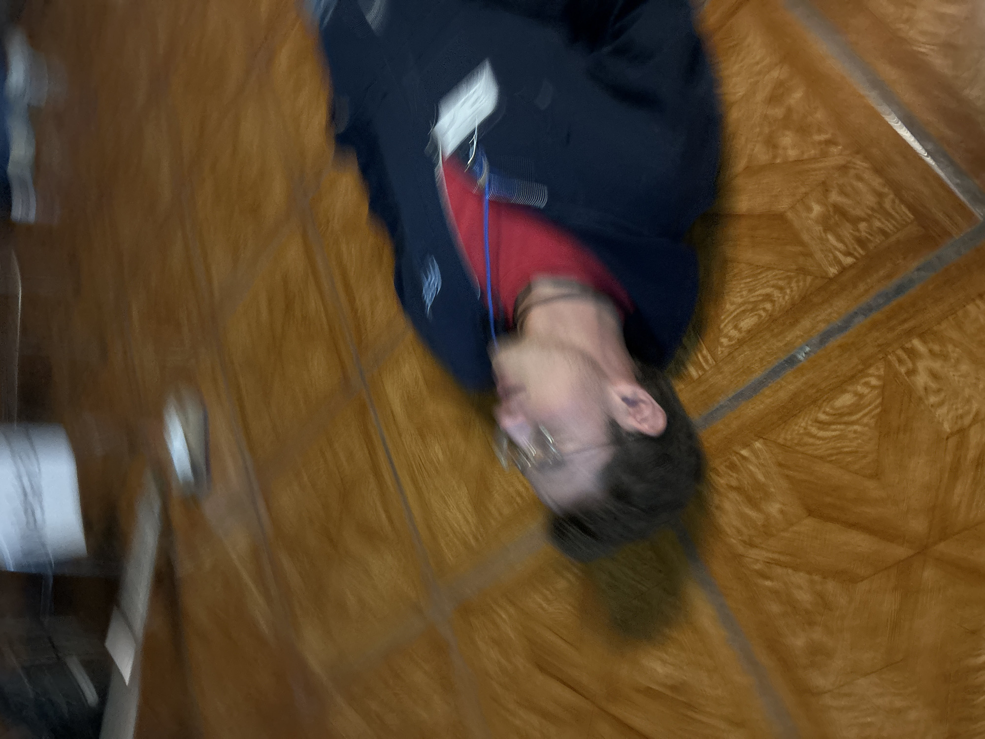 Person in red shirt lying on indoor floor