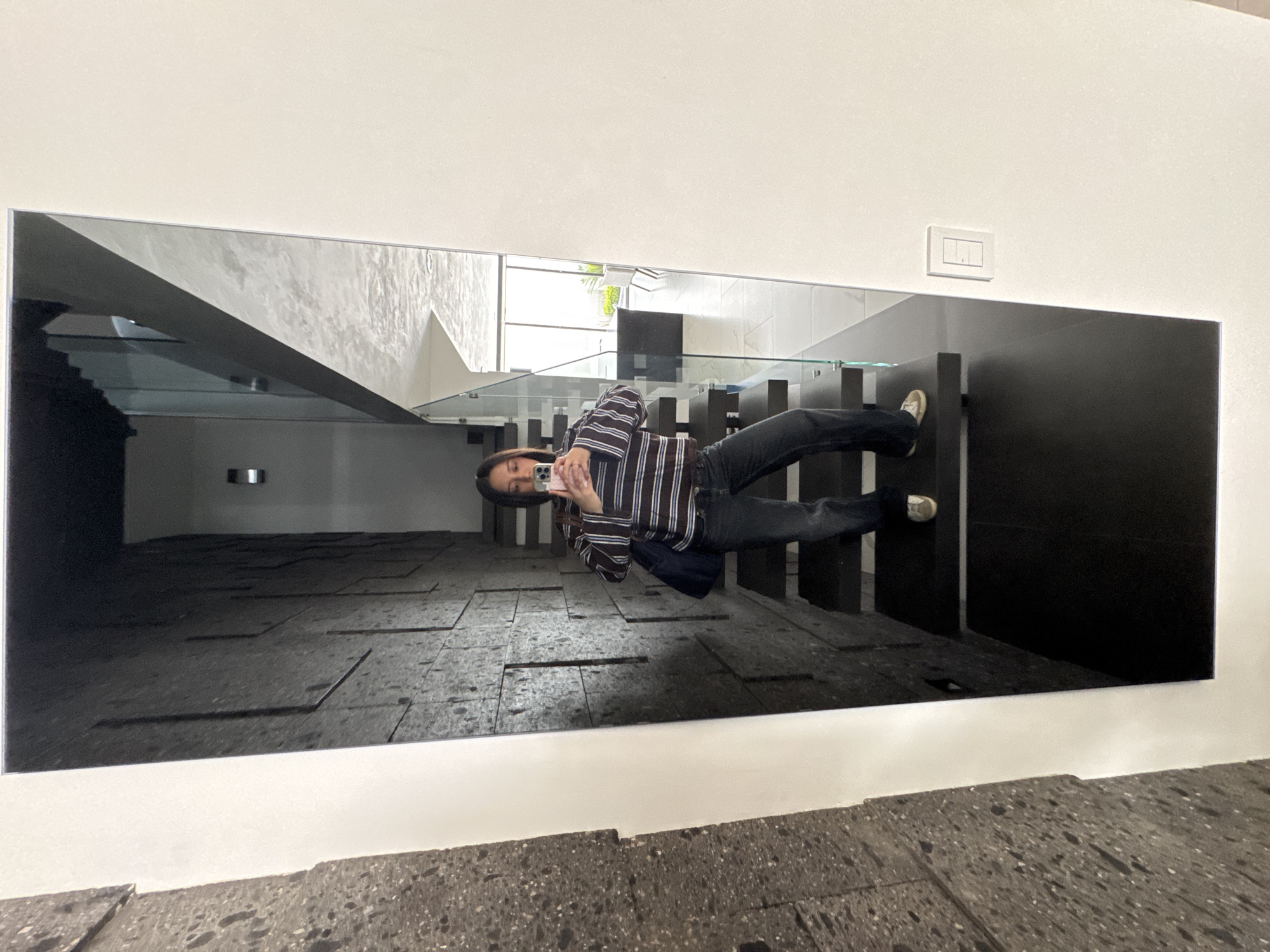 Person takes mirror selfie in modern Puebla building
