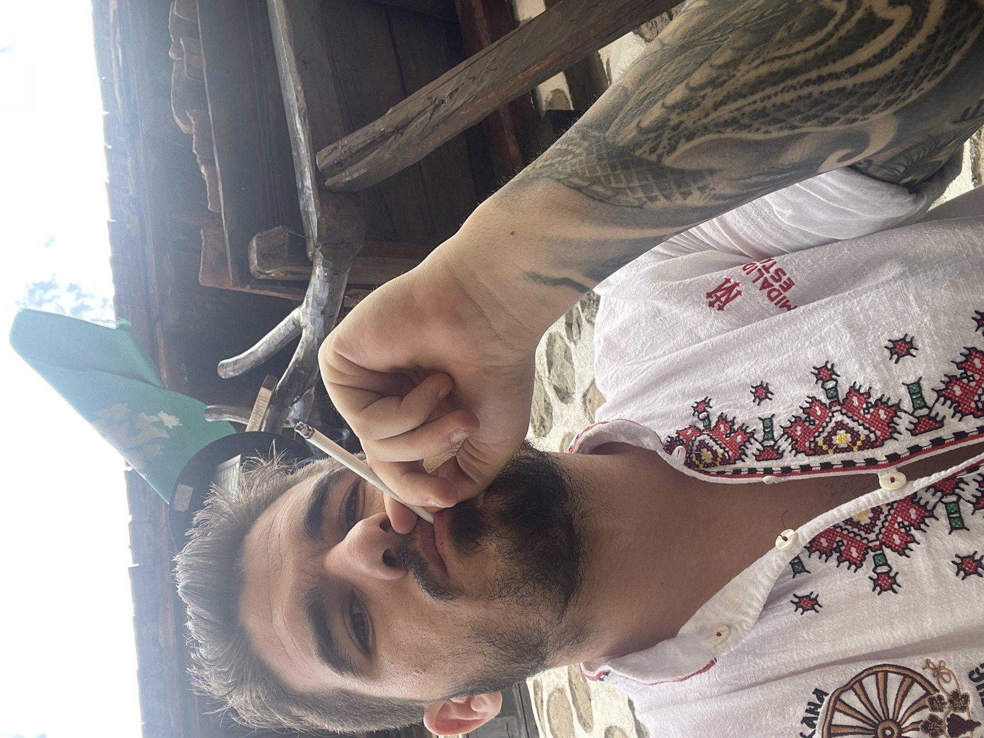 Man photographs himself smoking near kitchen with roasted peppers