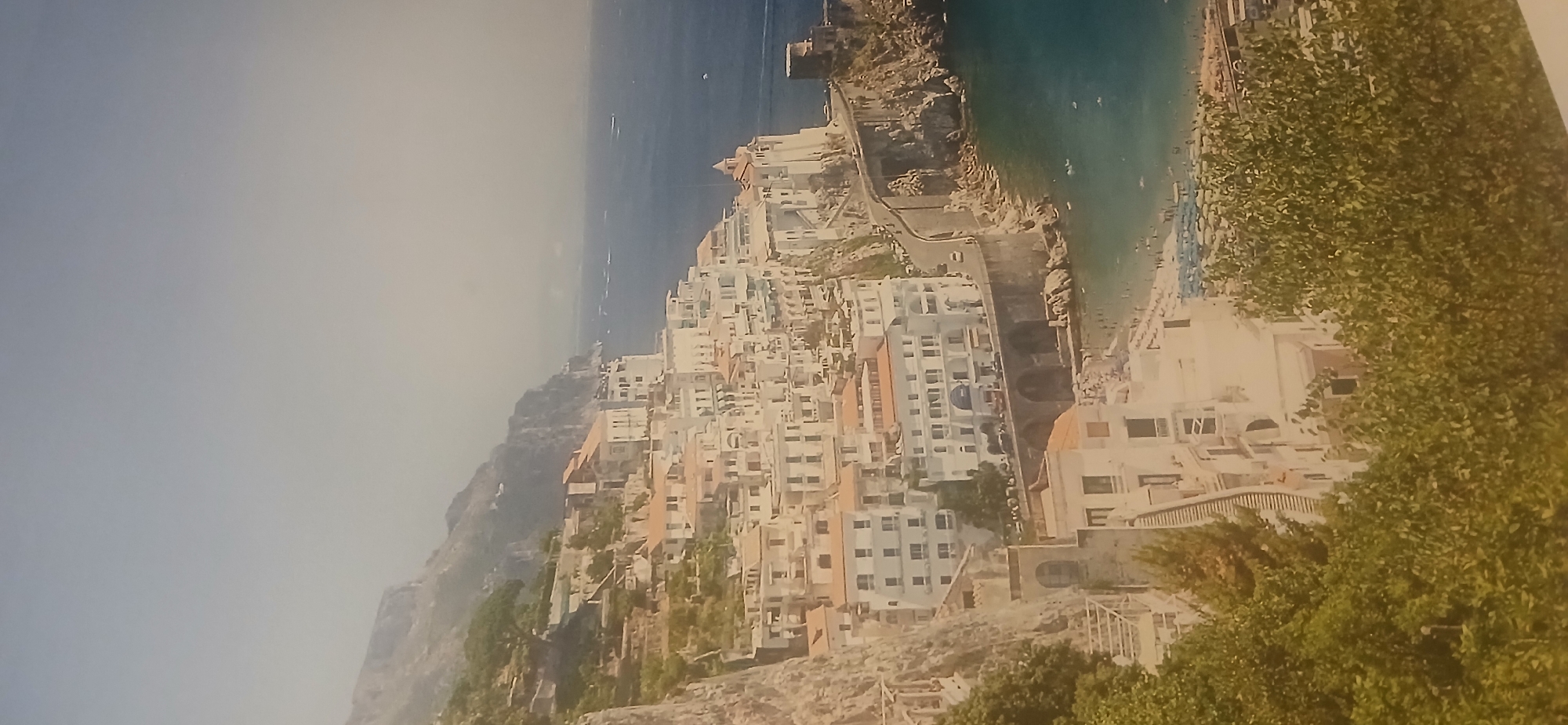 Coastal hillside town with white buildings documented by witness