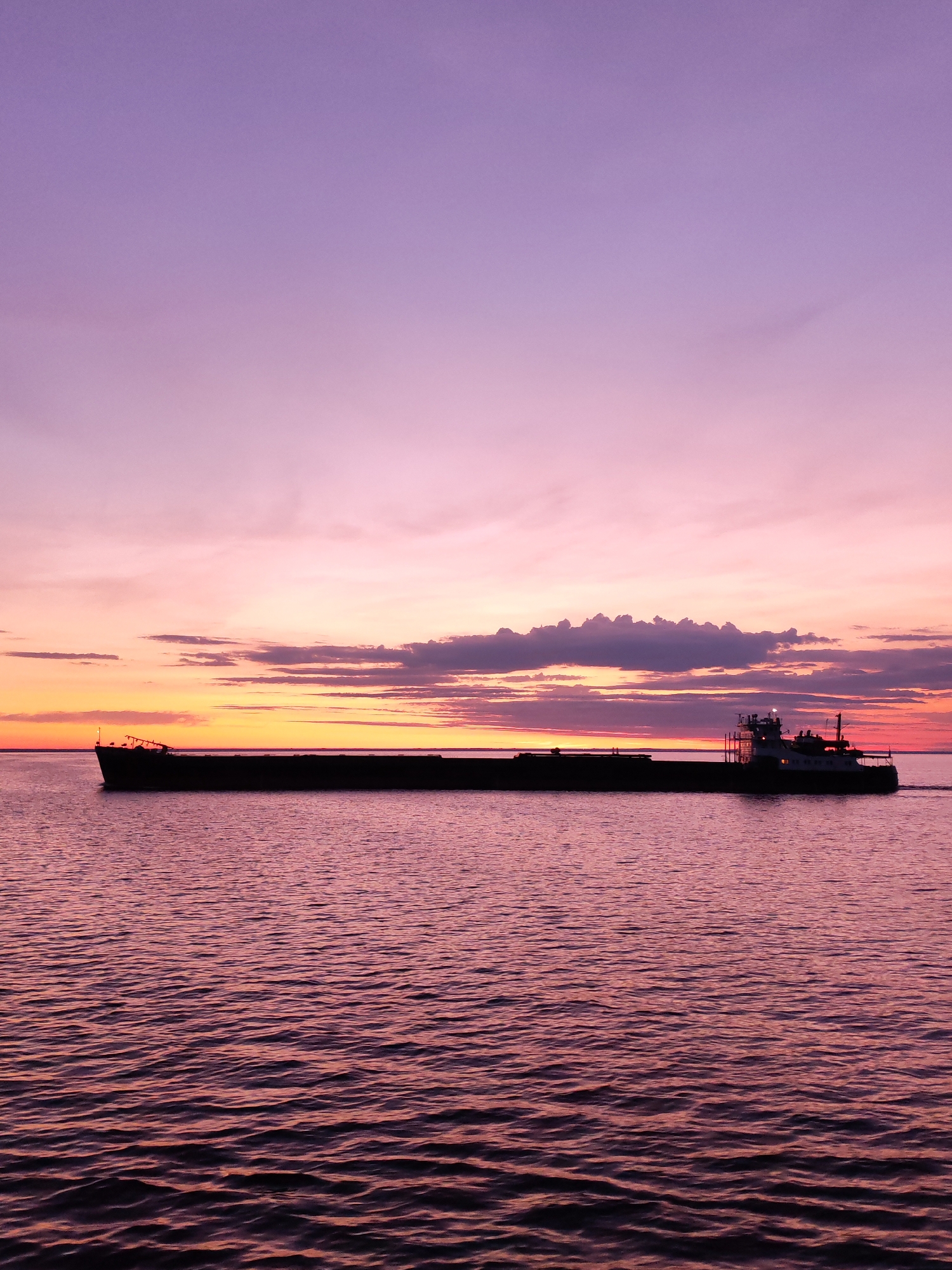 Barge crosses Russian waters during vibrant sunset display