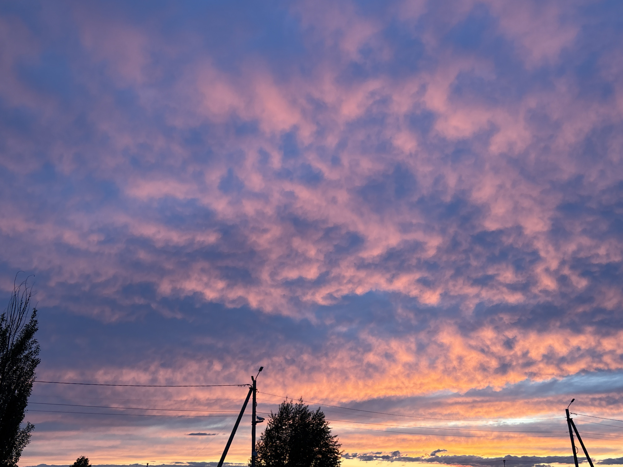 Dramatic sunset displays colorful clouds over residential area