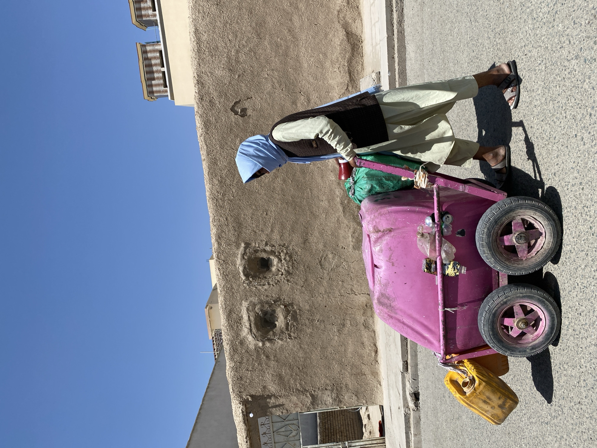 Street vendors and water containers on a Kandahar street