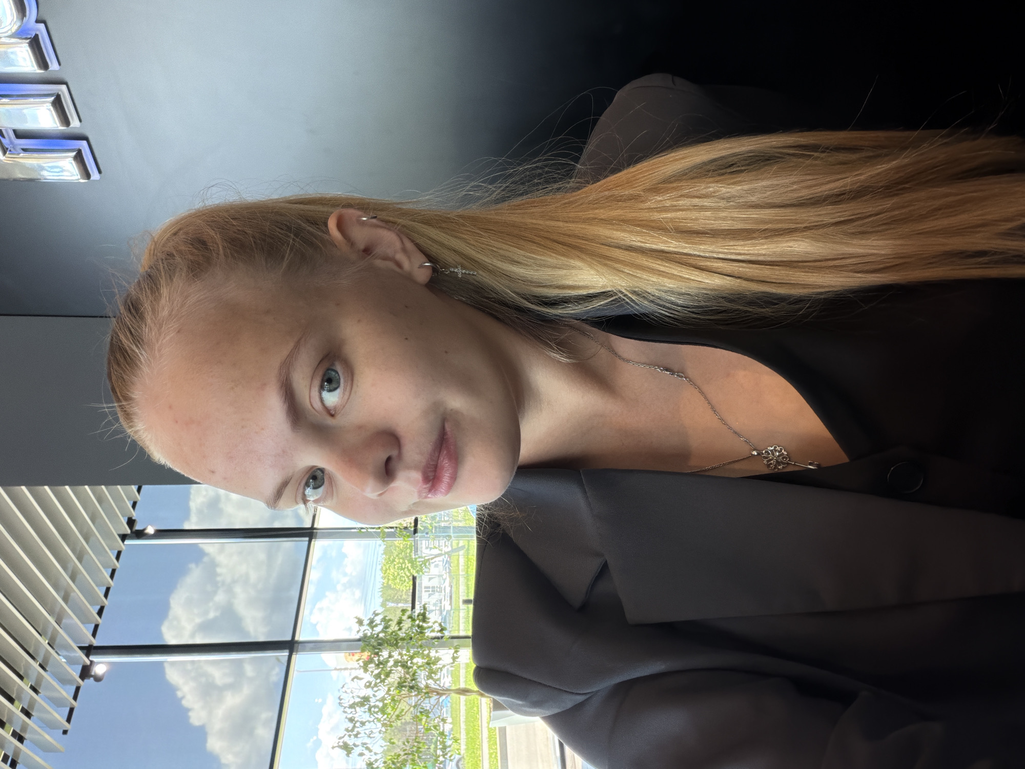 Woman in dark blazer observed sitting indoors in Izhevsk