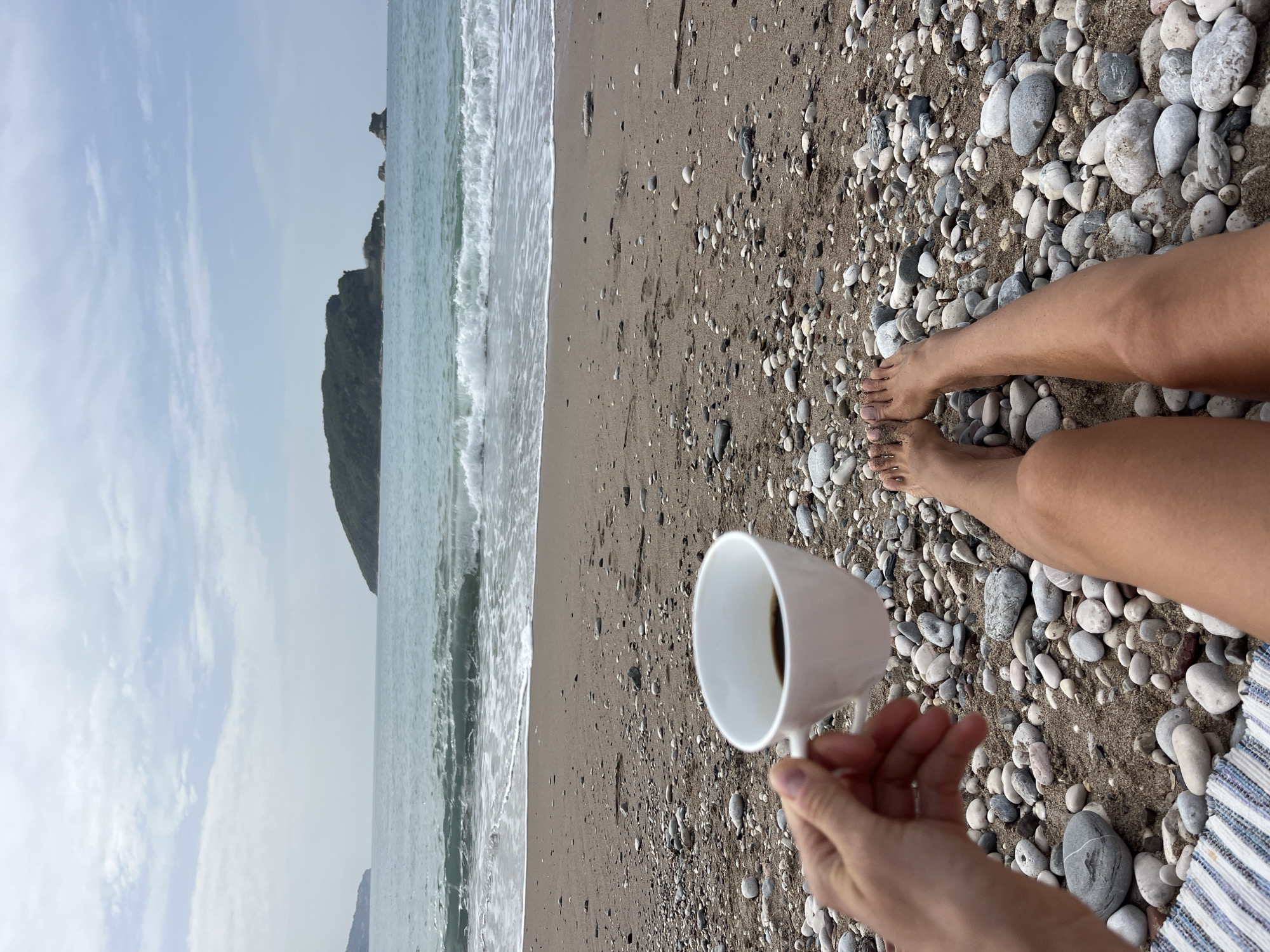 Person sits alone on overcast Budva beach morning