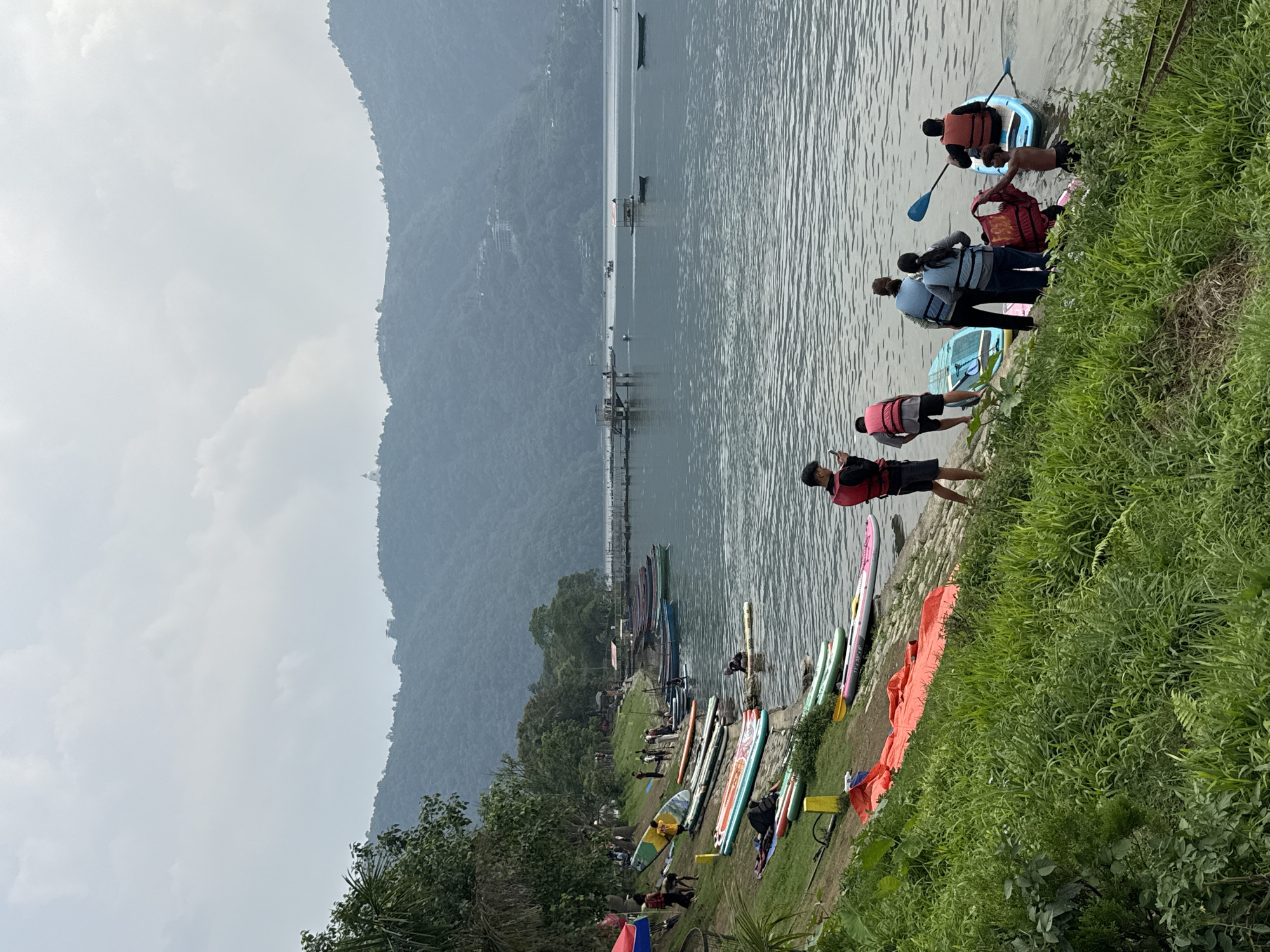 Paddleboarding activity observed at Nepal's Phewa Lake under cloudy skies