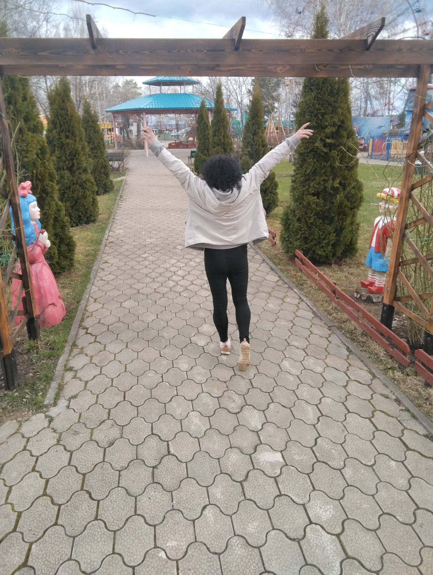 Woman enjoys morning at Chaikovsky amusement park, poses with statues