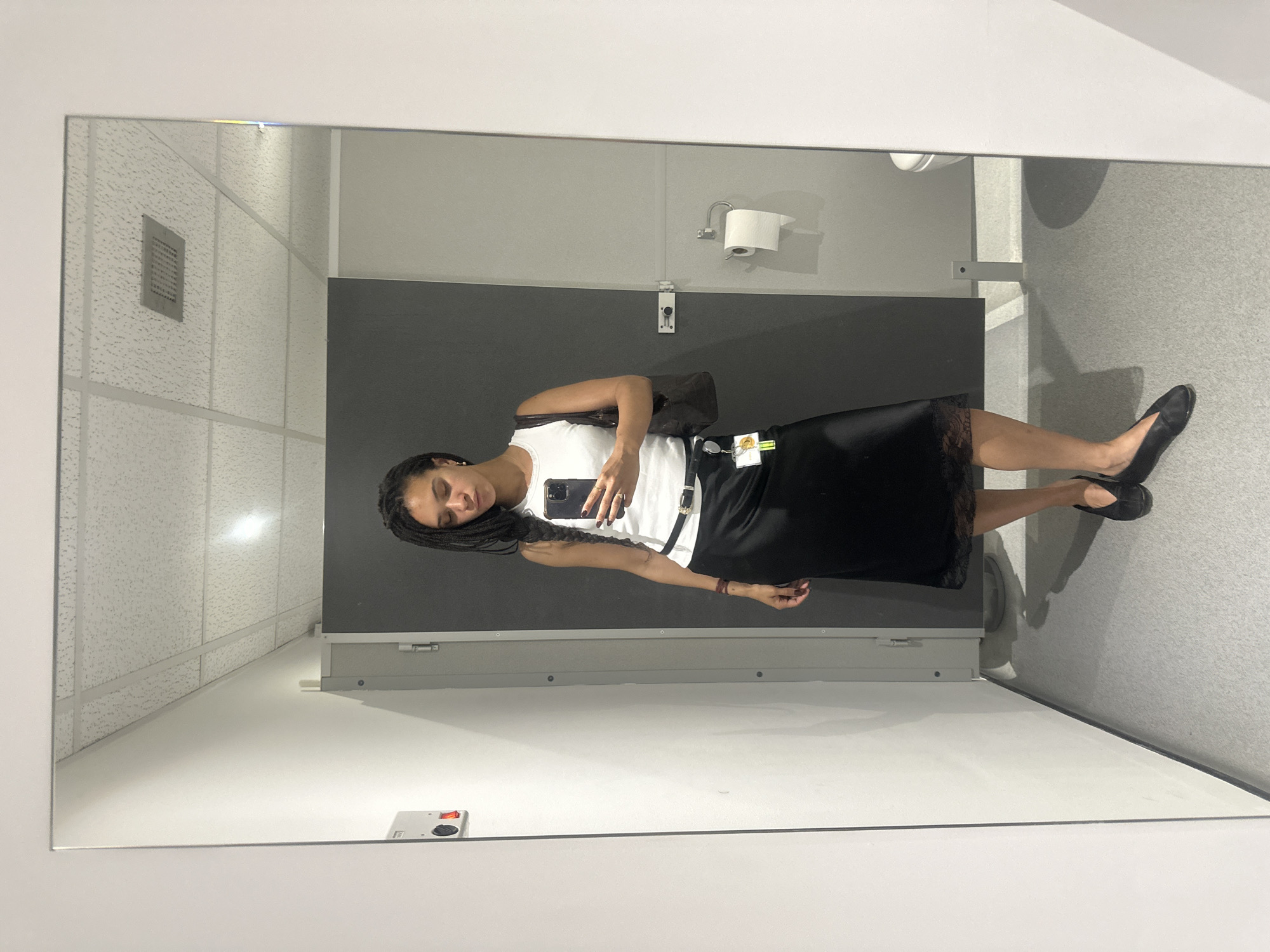 Woman takes mirror selfie in London bathroom stall