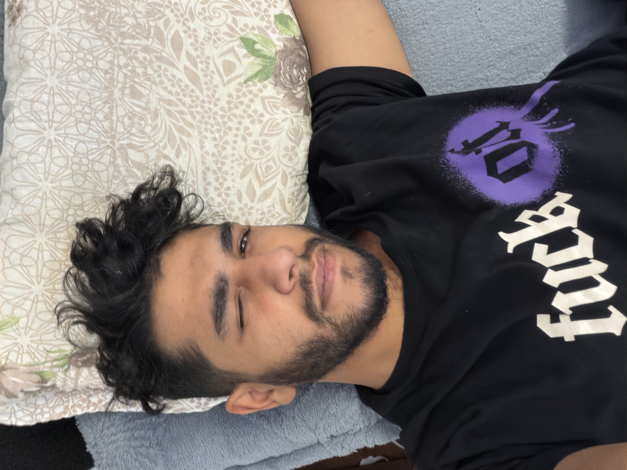 Man winks at camera while resting on pillow