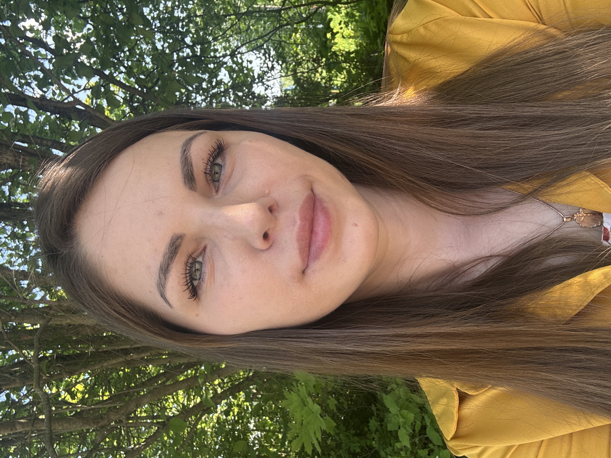 Woman takes outdoor selfies on sunny morning in Shevlyakovo