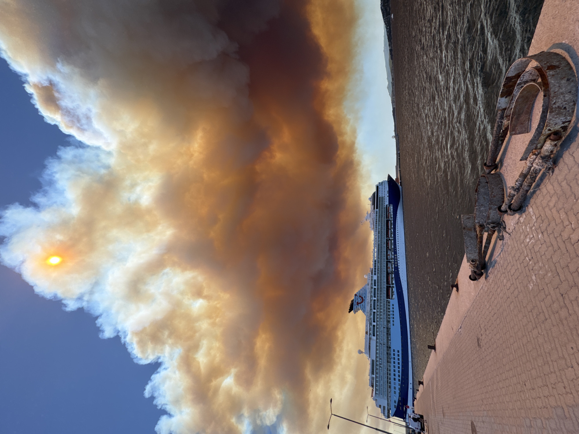 Wildfire smoke blankets Palamós harbor over docked cruise ship