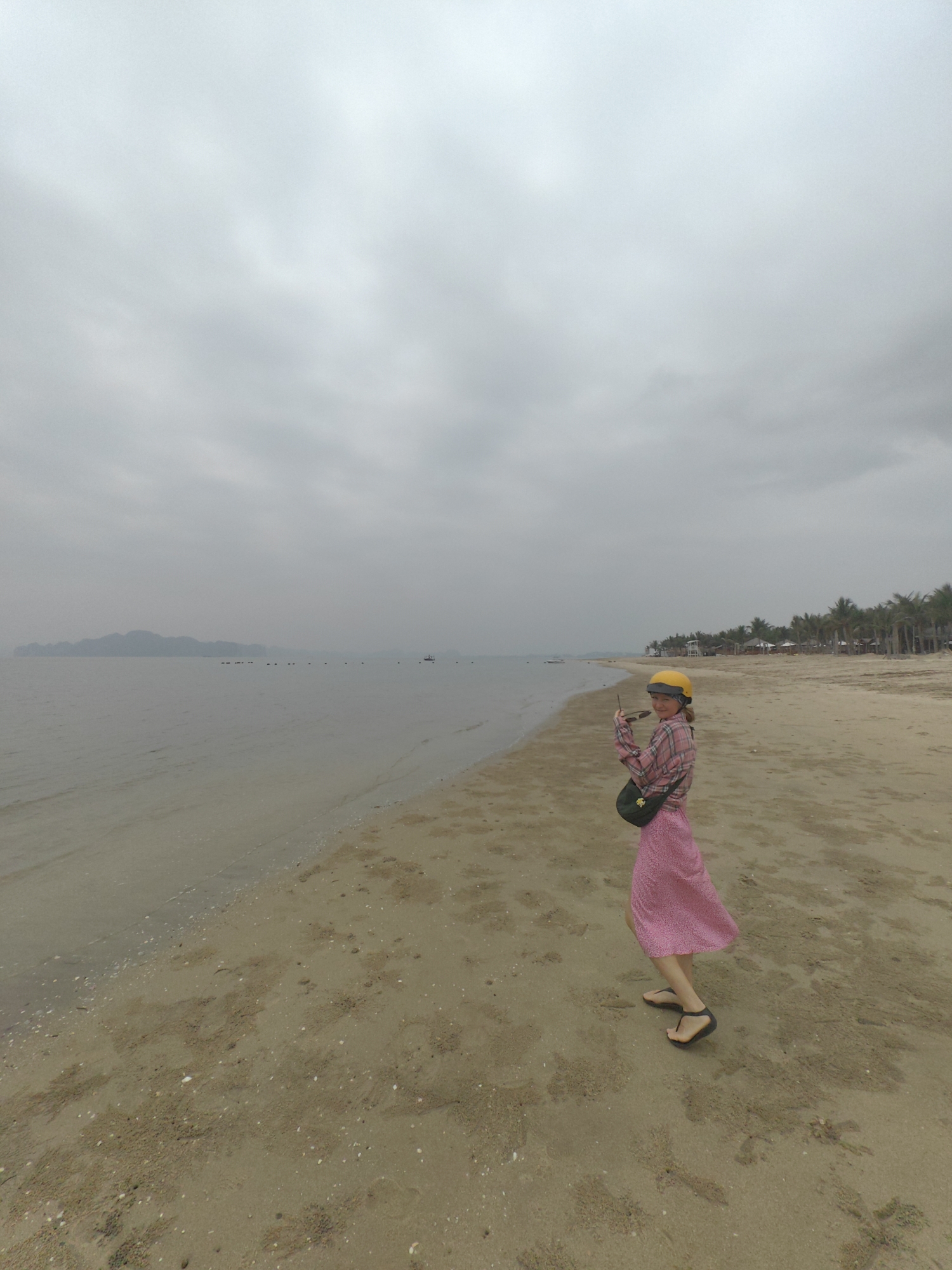 Couple explores Vietnamese beach wearing safety helmets during morning visit