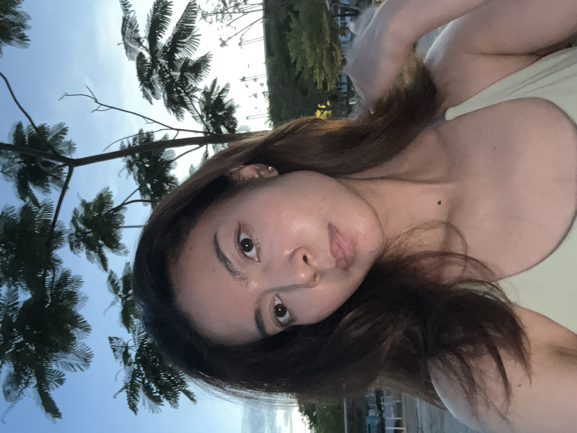Woman takes outdoor selfies in Thailand during twilight hours