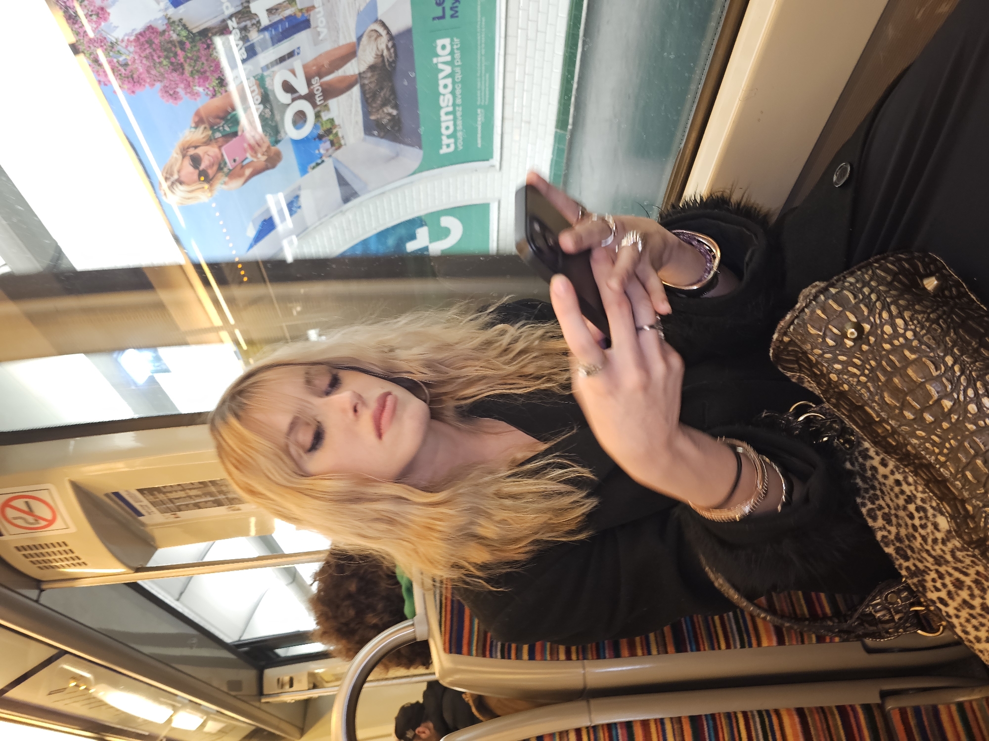 Woman sleeps, uses phone on Paris public transport