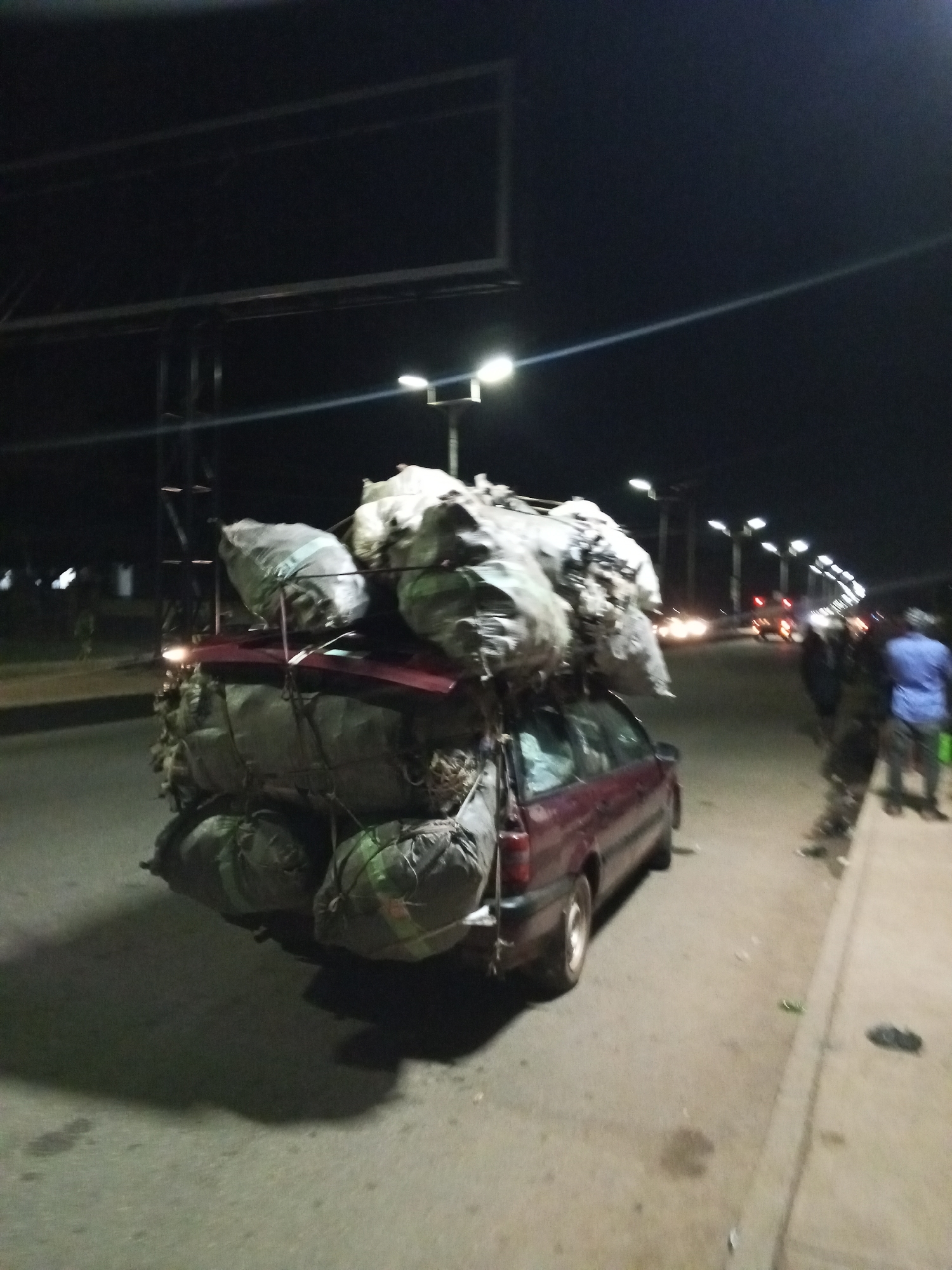 Heavy cargo transport, street vendors active during Bukuru evening hours