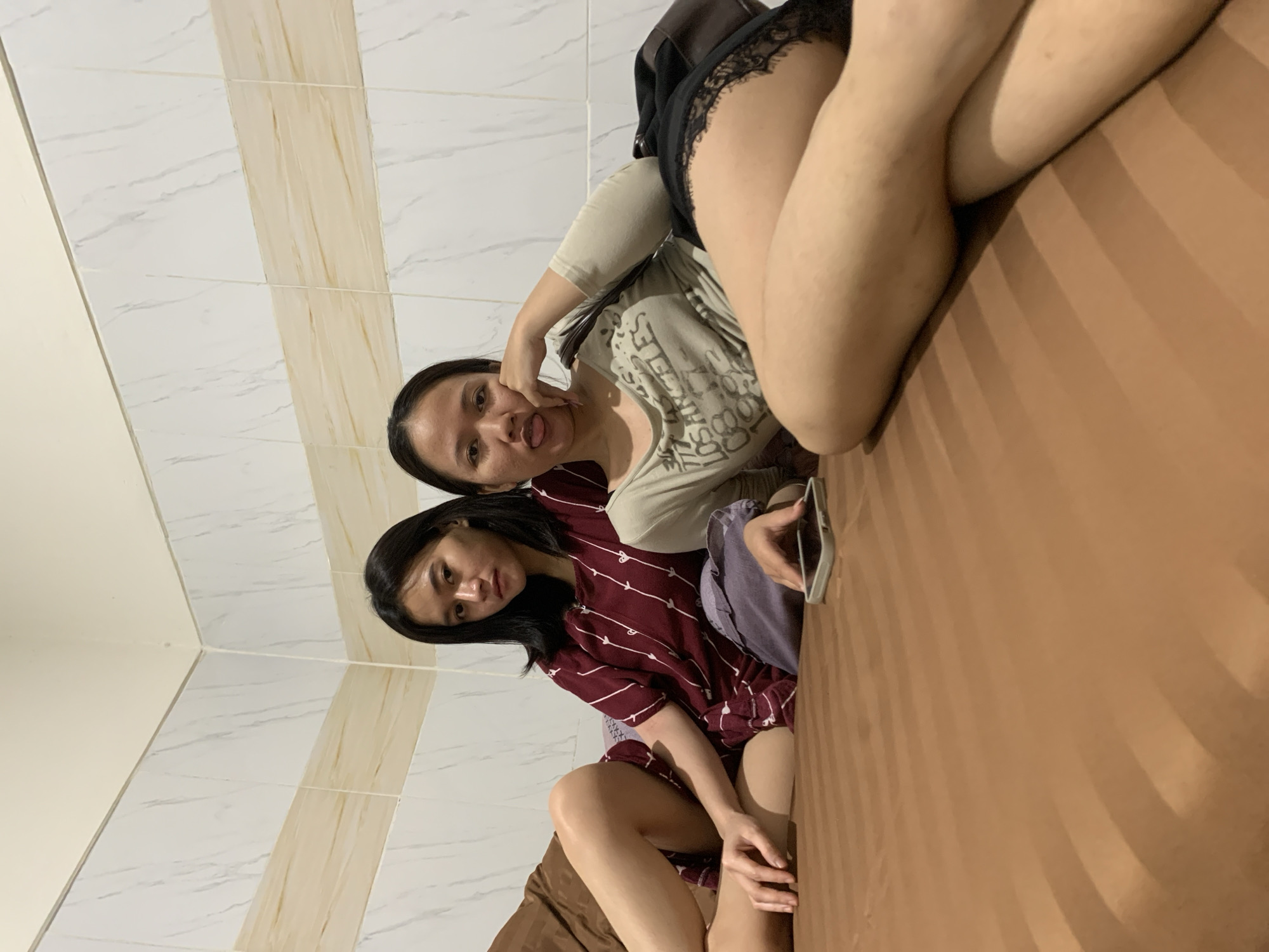Two women rest on bed in Denpasar room