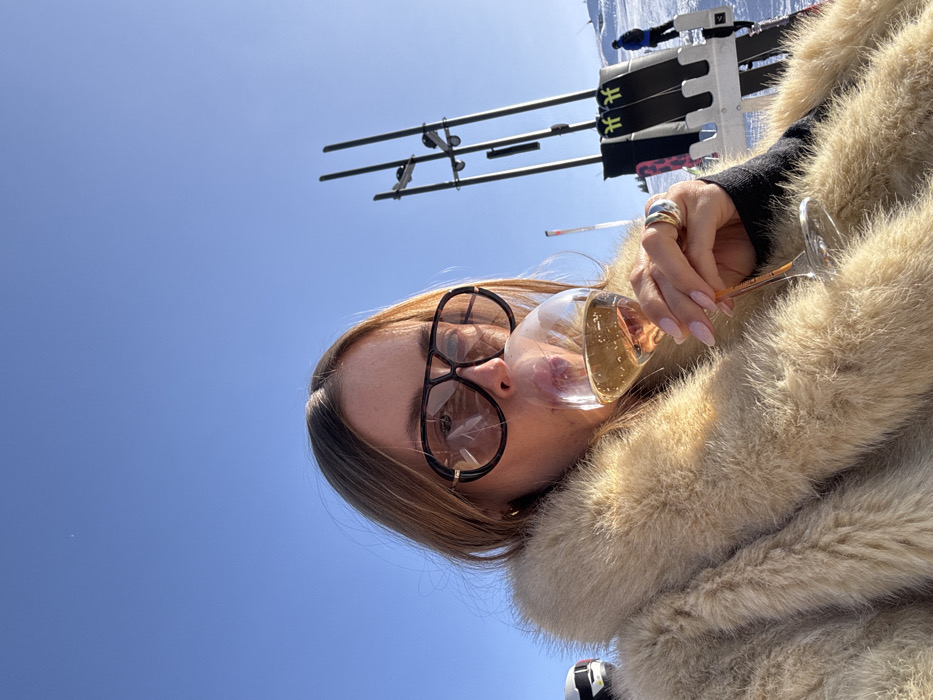 Woman enjoys après-ski drinks at Courchevel resort terrace