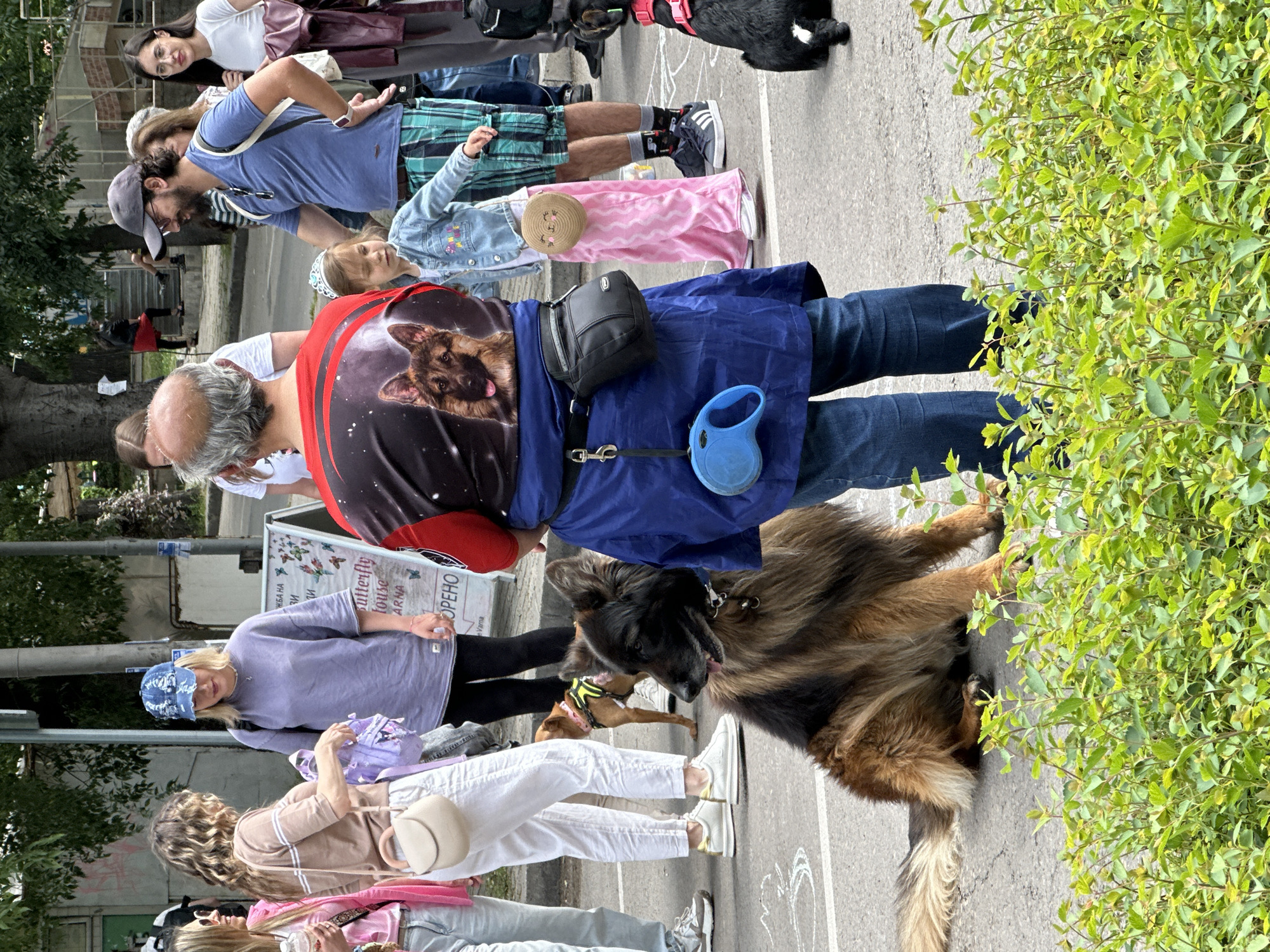 Street gathering with families, dogs, military vehicle in Varna