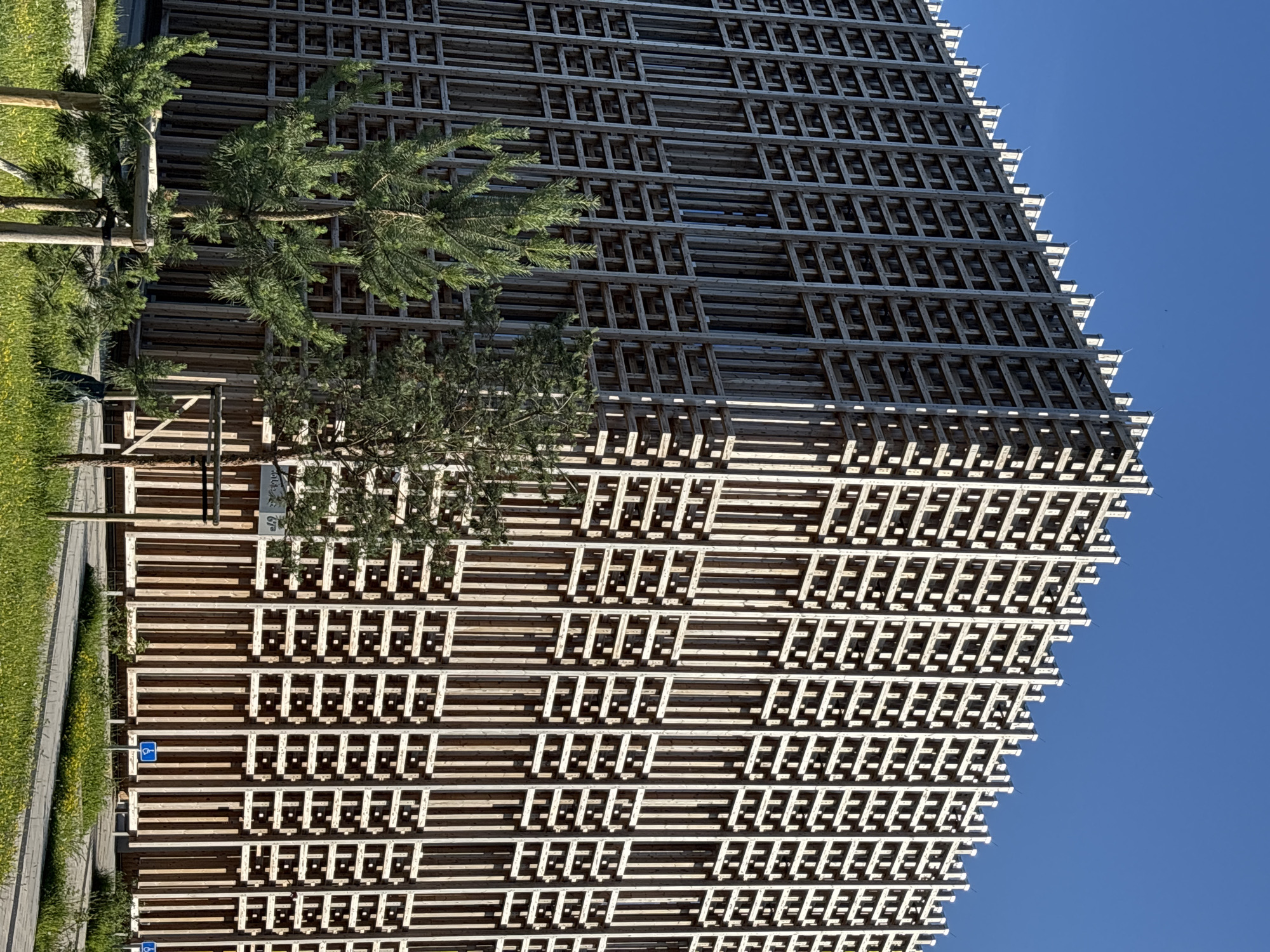 Tallinn building with wooden lattice facade, pink shrubs in bloom